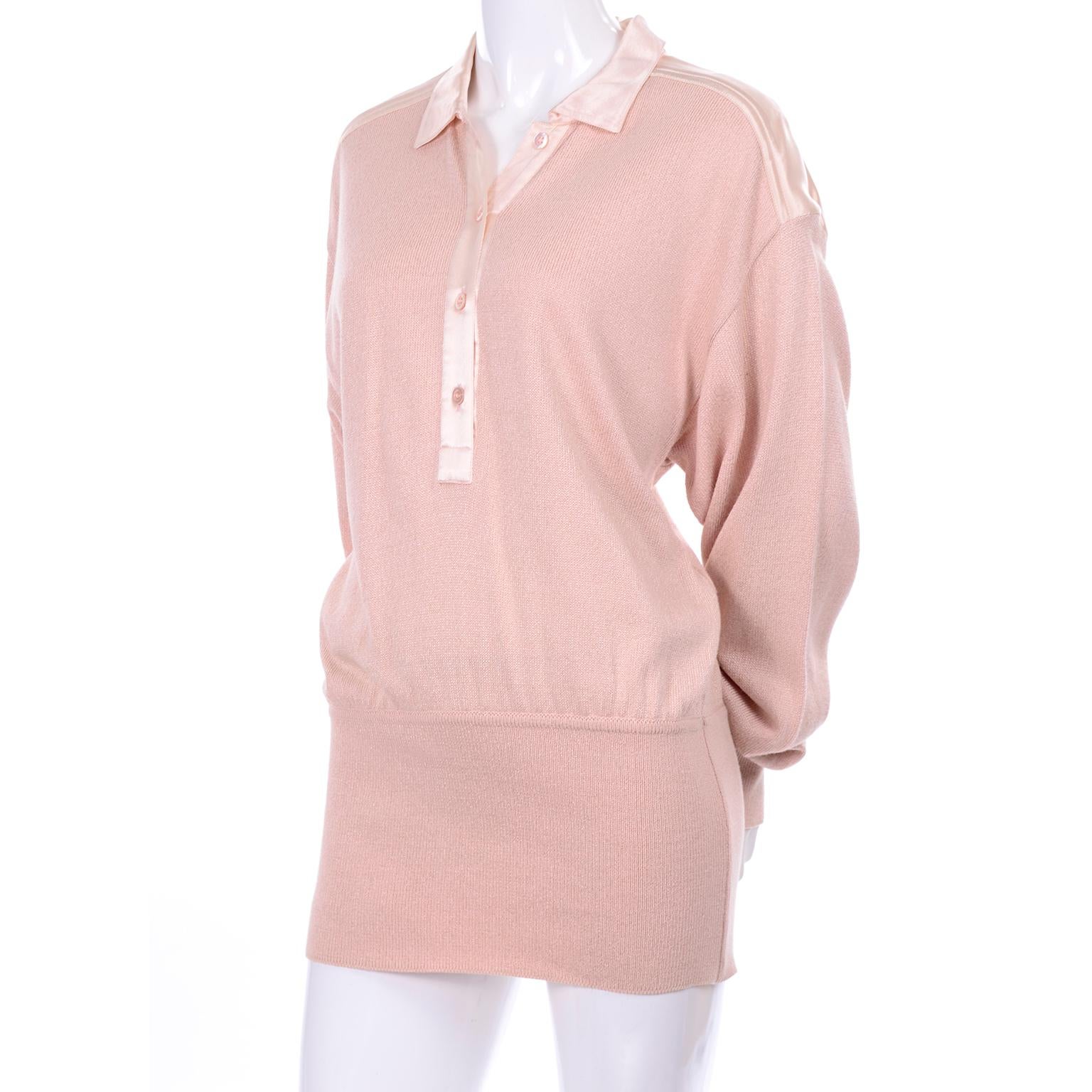 Escada pale peachy nude pink cotton/silk/rayon blend sweater with satin trim on the shoulders and collar. The top has buttons down the first half, with four buttons and has a thick elastic band around the hips or waist, depending on how you choose