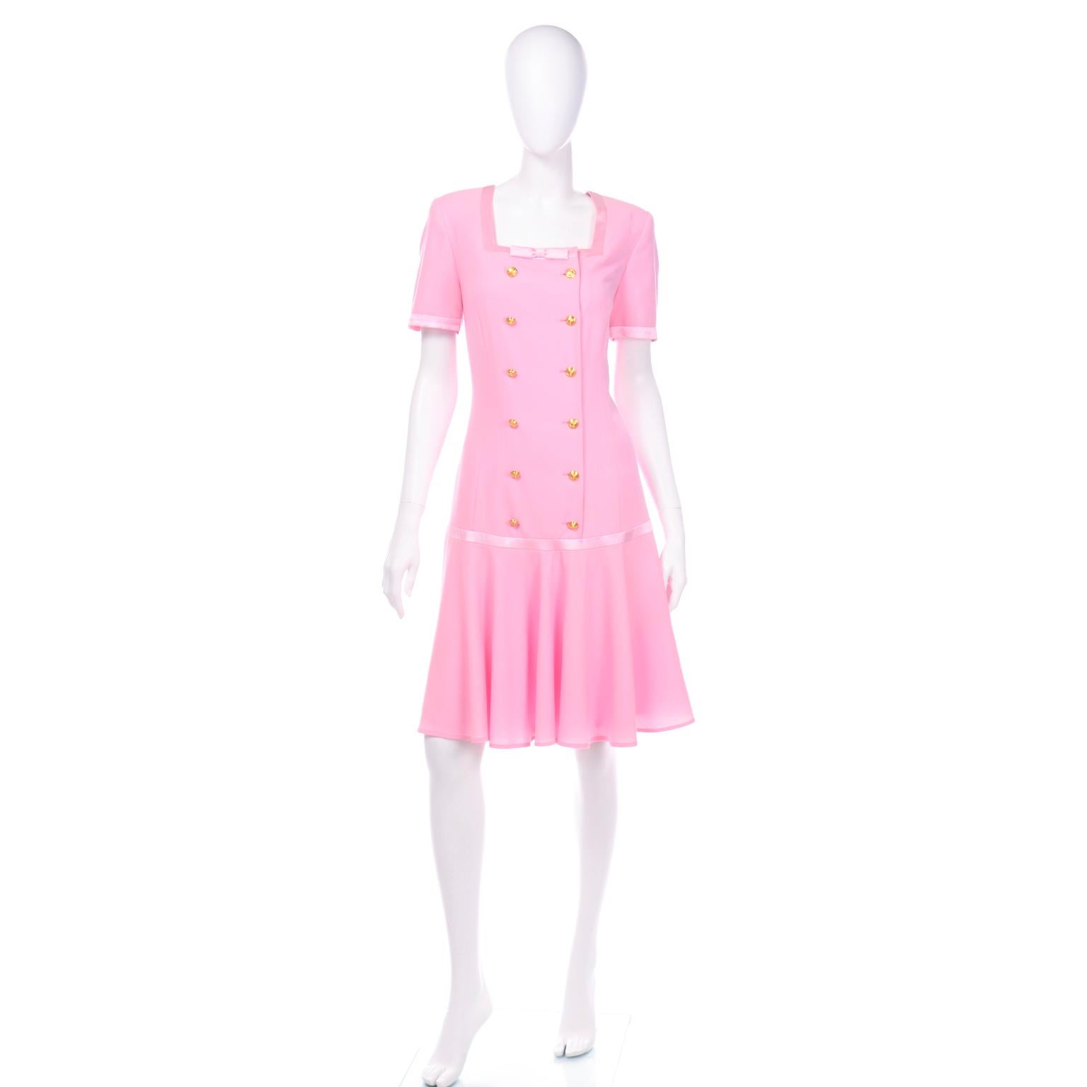 We think this  incredible vintage Margaretha Ley Escada dress would be perfect for a  wedding or garden party guest. This double breasted dress is in a light pink wool with silk ribbon trim and gold tone rose engraved buttons. The dress has a square
