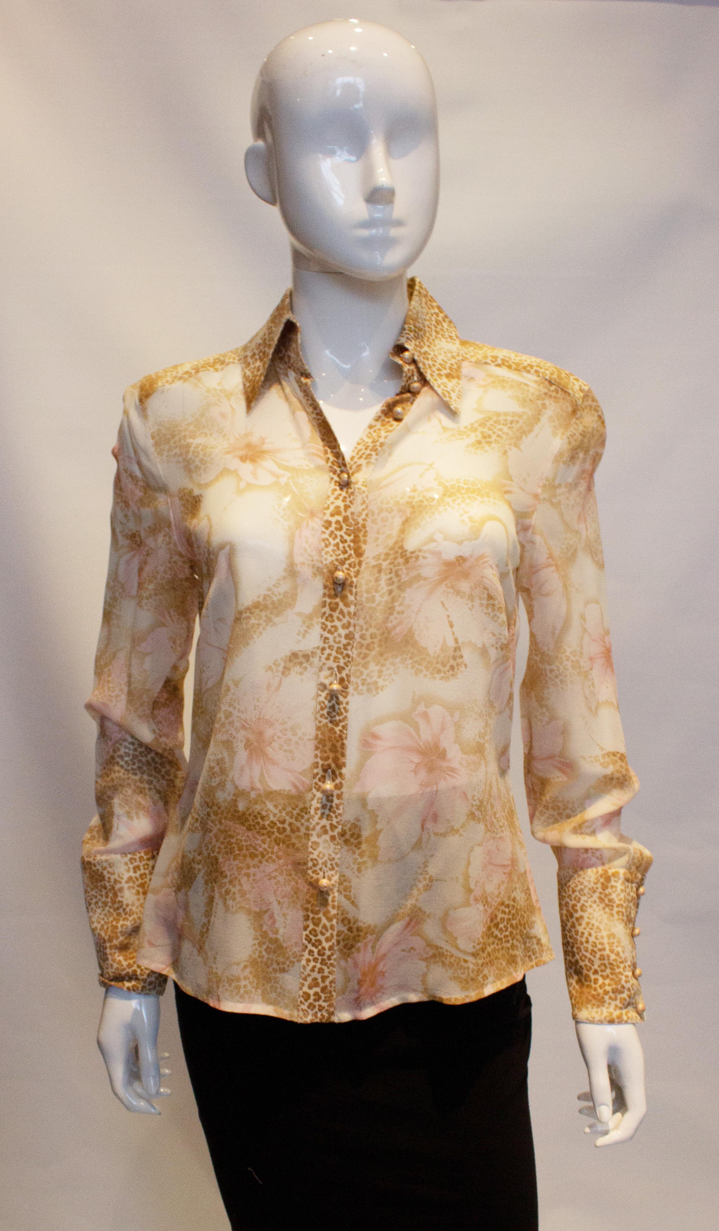 A pretty vintage silk shirt by Escada. In a mix animal print and floral, the shirt has a front button opening with four button cuff. Size 36  Measurements Bust 36'', length  27''