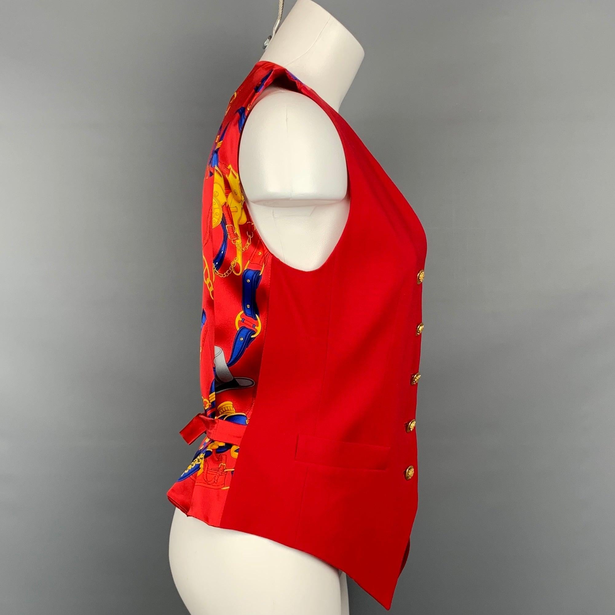 Vintage ESCADA vest comes in a red & blue equestrian print silk featuring 
back belt, front pockets, and gold tone button closure.
Very Good
Pre-Owned Condition. 

Marked:   34 

Measurements: 
 
Shoulder: 13.5 inches  Bust: 32 inches  Length: 20