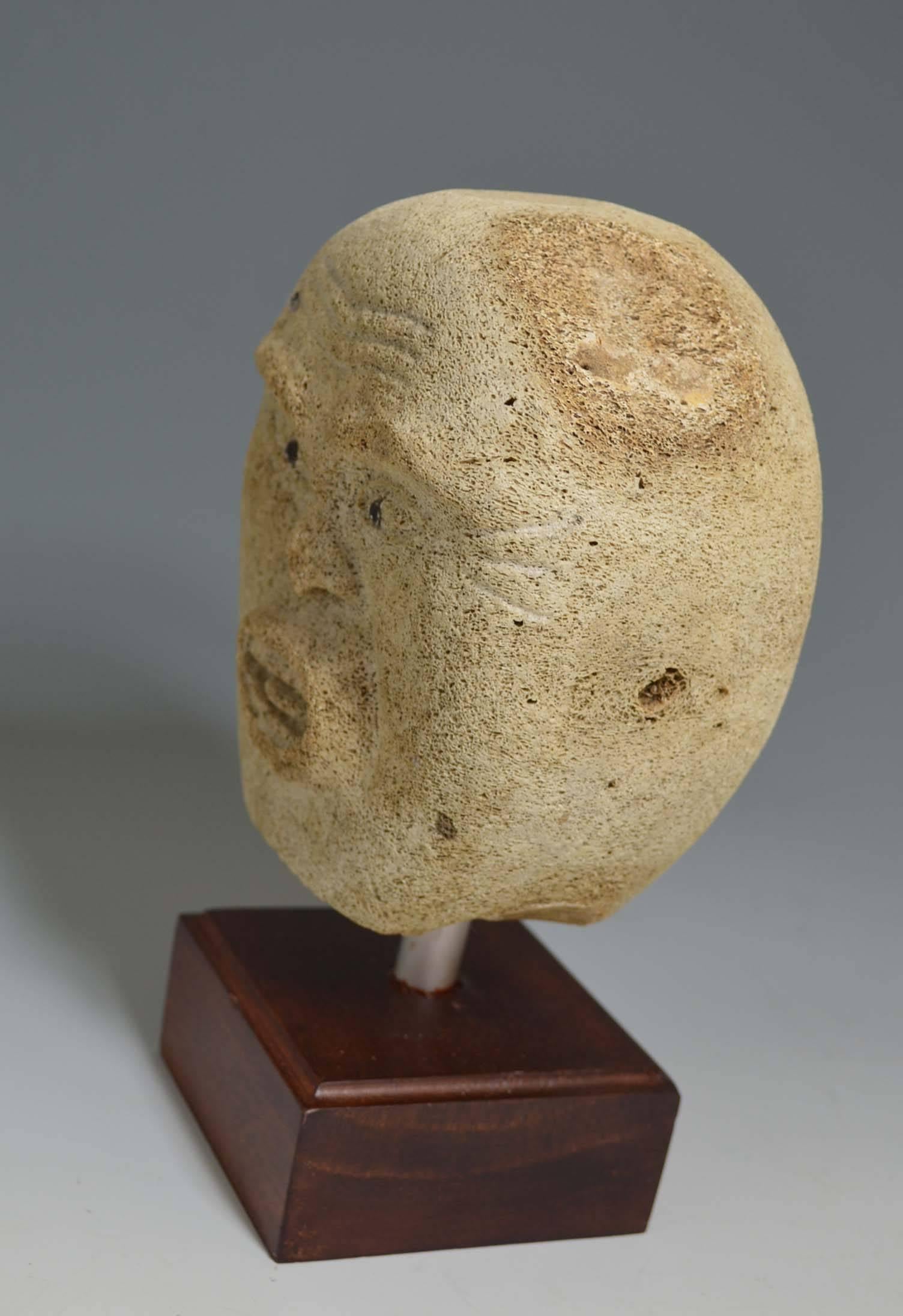 A fine and striking vintage Eskimo shaman head carving
Carved by Alaskan artist Embert Ozeva (signed), 
Alaska, circa 1970, 
Fossilized whalebone. 
Size H 16 cm W 14 cm D 9 cm
Presented on custom display stand.
     