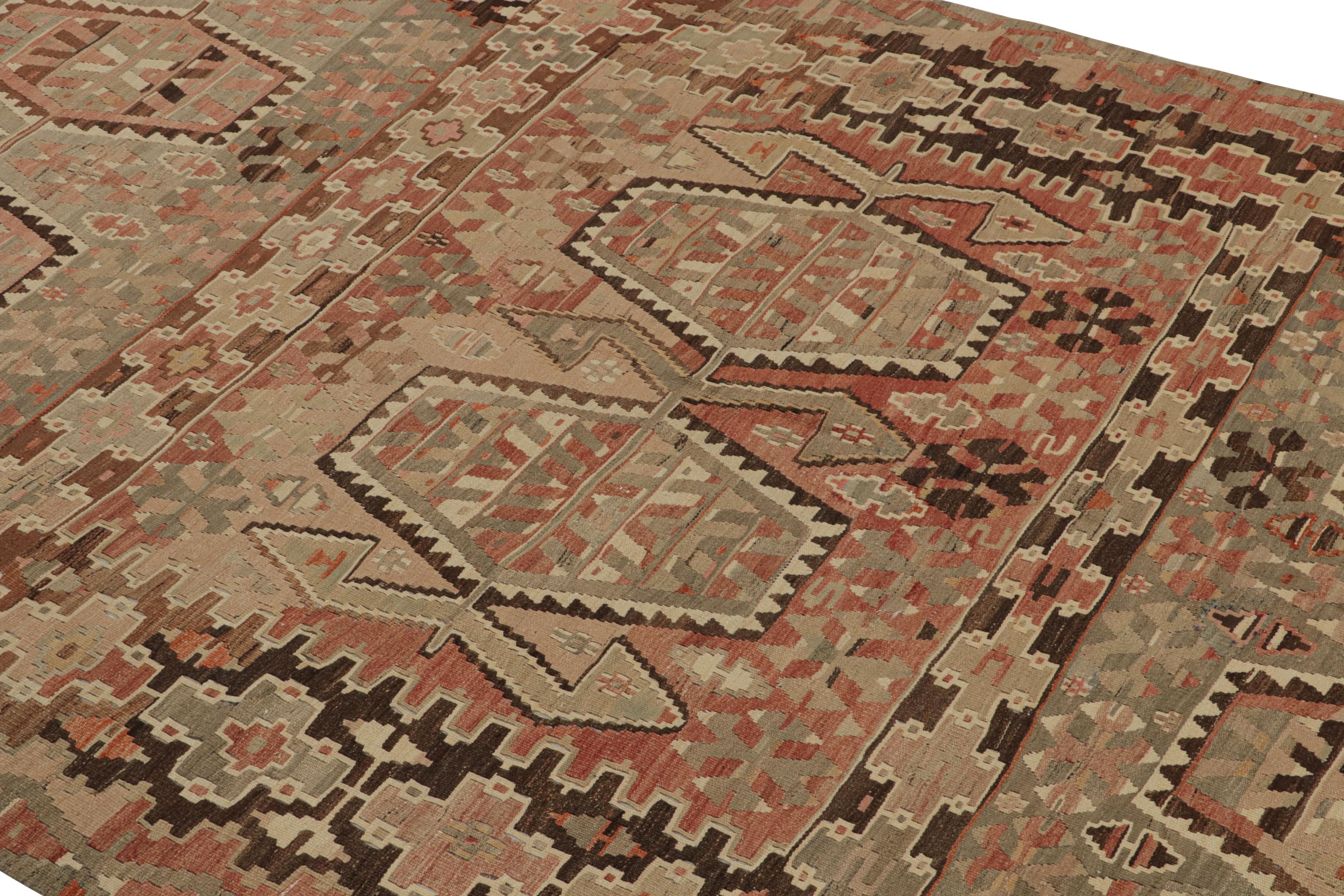 Originating from Turkey between 1940-1950, this vintage Esme wool Kilim rug features a high-quality flat-weave and a unique, vibrant array of field colorways against the beige background, marrying a distinct pageantry of inviting pastels with an