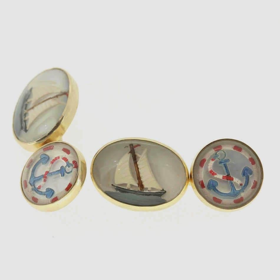 This is a set of 14ct yellow gold cufflinks. These essex crystal cufflinks are beautifully crafted displaying a vivid image of a sailing boat and anchor. They also feature a chain and bar link fastening.

Condition: Used (Very Good)
Weight: 10.3