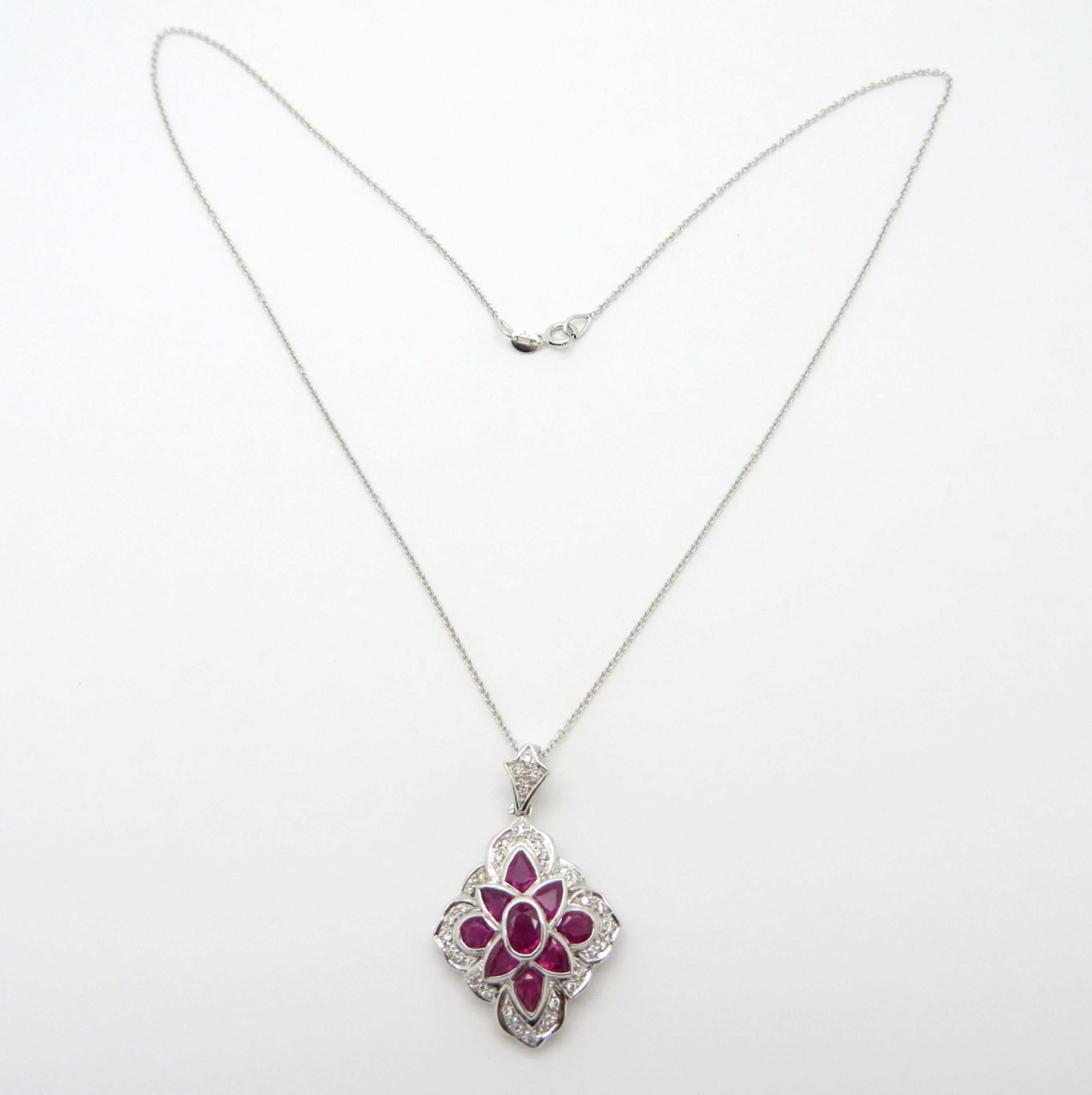 For sale is a beautiful Ruby and Diamond Pendant crafted out of 14K White Gold!
Showcasing 9 fine quality natural Rubies, with various measurements, weighing 2.00 carats.
Accented by 28 Round Brilliant Cut bead set diamonds, weighing 0.15 carats,