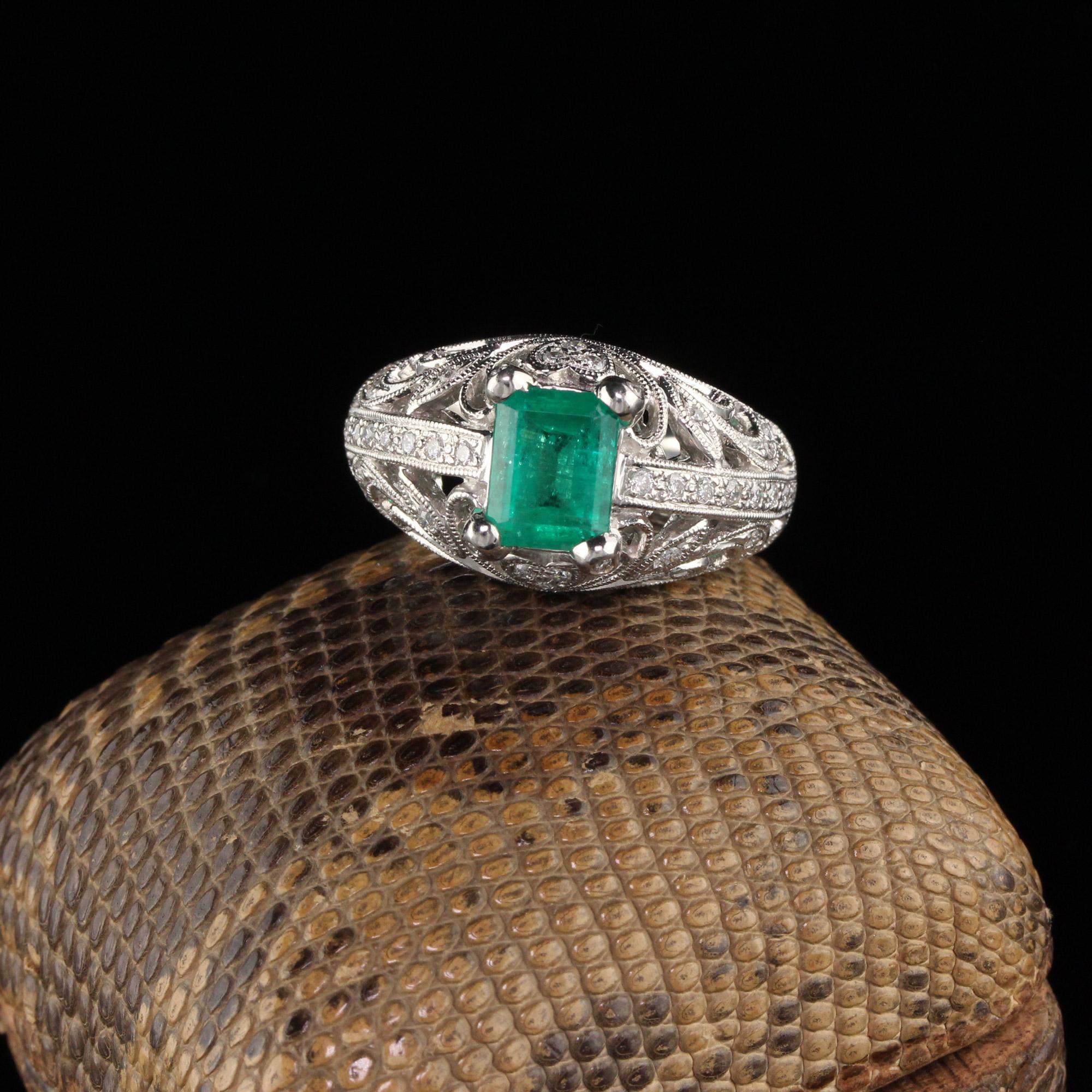 Elaborately designed diamond ring with emerald center.

Metal: 18K White Gold

Weight: 8.7 Grams

Total Diamond Weight: Approximately 0.25 ct.

Diamond Color: H

Diamond Clarity: SI1

Gemstone Weight: Approximately 1.20 ct.

Ring Size: 7