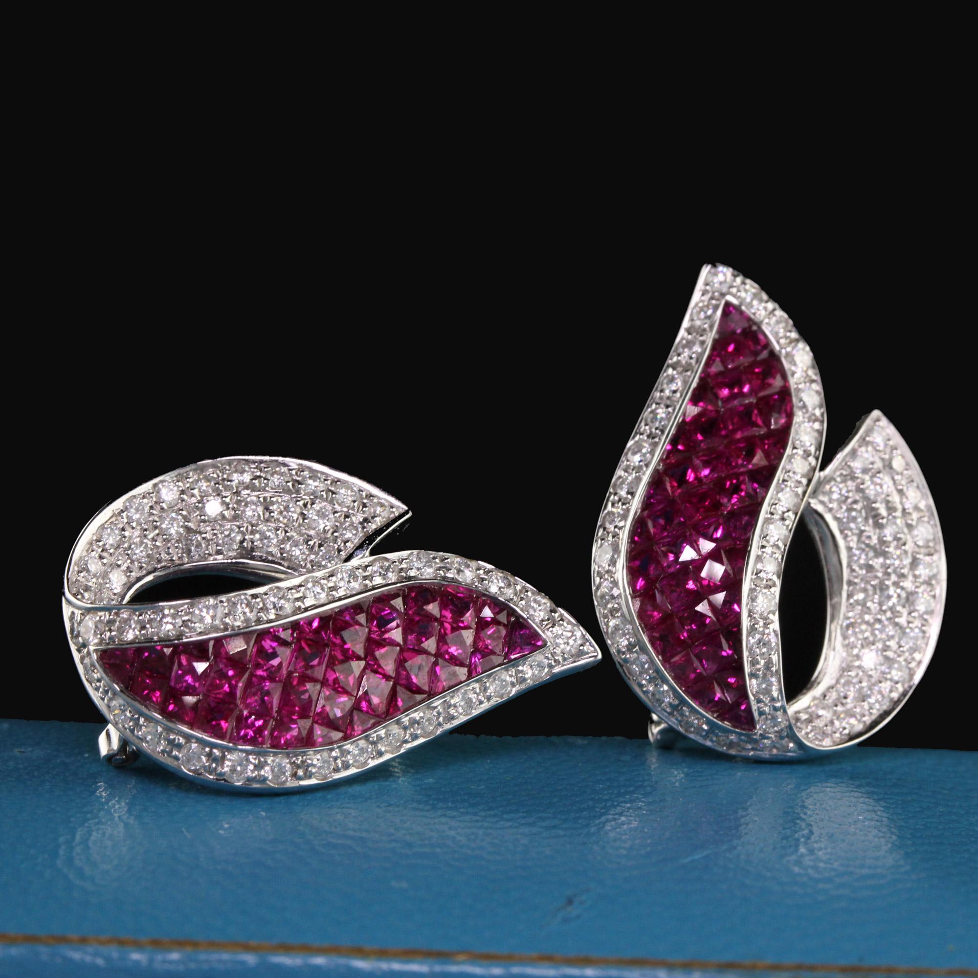 Dazzling ruby and diamond earrings with elaborate design.

Metal: 18K White Gold

Weight: 9.2 Grams

Diamond Weight: Approximately 2.0 CTS

Diamond Color: G

Diamond Clarity: VS2

Gemstone Weight: Approx. 5 ct. ruby

Measurements: 26.20 x 18.52 mm