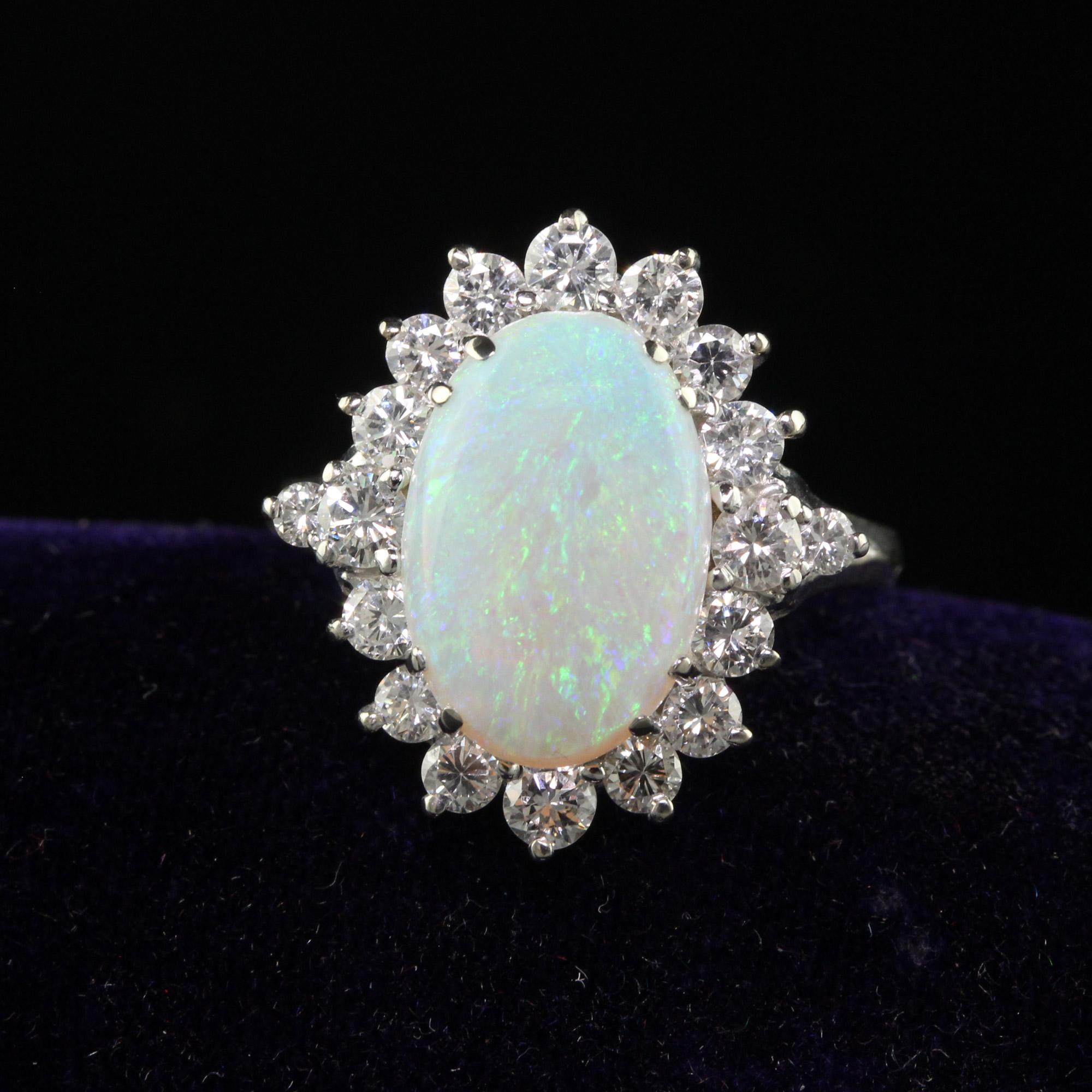 Beautiful Vintage Estate 18K White Gold Natural Opal and Diamond Cocktail Ring. This beautiful vintage estate opal ring is crafted in 18k white gold. This ring features a gorgeous natural opal in the center that has a beautiful play of colors of