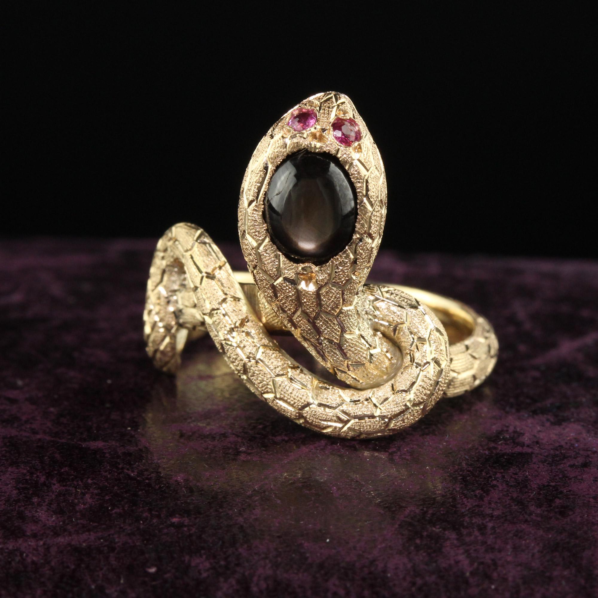 Beautiful Vintage Estate 18K Yellow Gold Black Star Sapphire and Ruby Snake Ring. This beautiful snake ring is crafted in 14k yellow gold. The head of the snake holds a black cabochon star sapphire with natural ruby eyes. The ring is in great