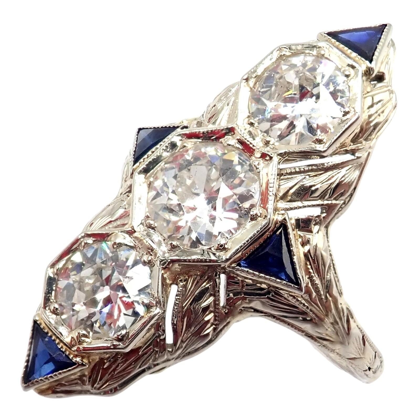 Anillo de oro blanco de 20 quilates con filigrana de diamantes y zafiros Art Decó VIntage Estate.
Este anillo Art Decó de época presenta una intrincada filigrana de oro blanco de 20k, engastada con tres diamantes talla minero antiguo que suman un