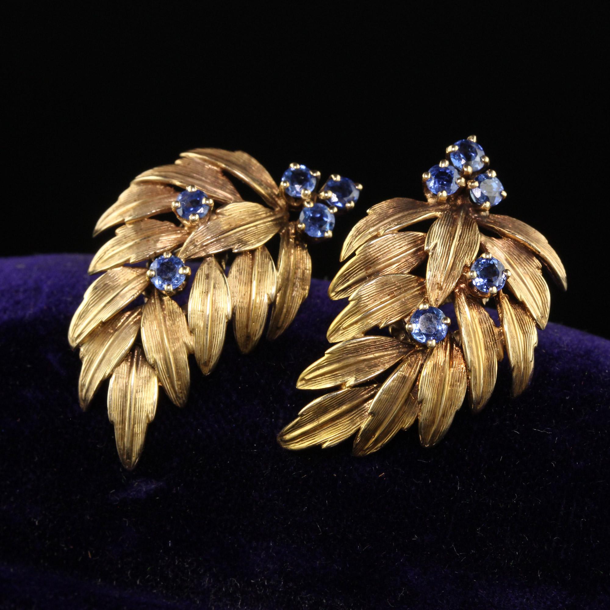 Beautiful Vintage Estate Dankner 14K Yellow Gold Sapphire Leaf Earrings. This beautiful pair of earrings are crafted in 14k yellow gold. The earrings are hallmarked by Henry Dankner and has a beautiful leaf design. The sapphires are natural and have