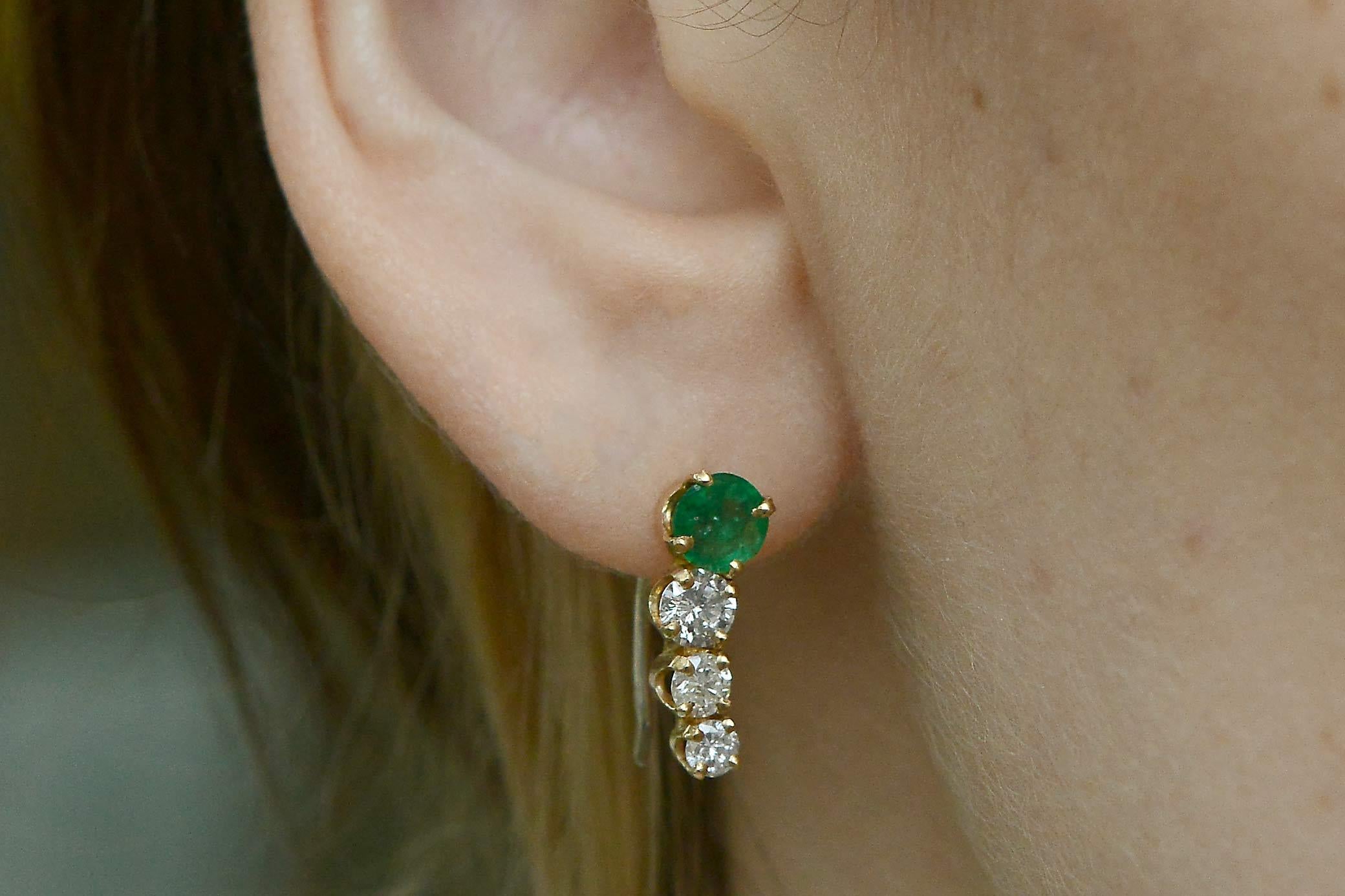 A sensational pair of emerald and diamond waterfall earrings. Situated on top are a set of gorgeous matched emeralds displaying a luscious green. Cascading down are a triplet of gleaming diamonds descending in size, all set in 14kt yellow gold.