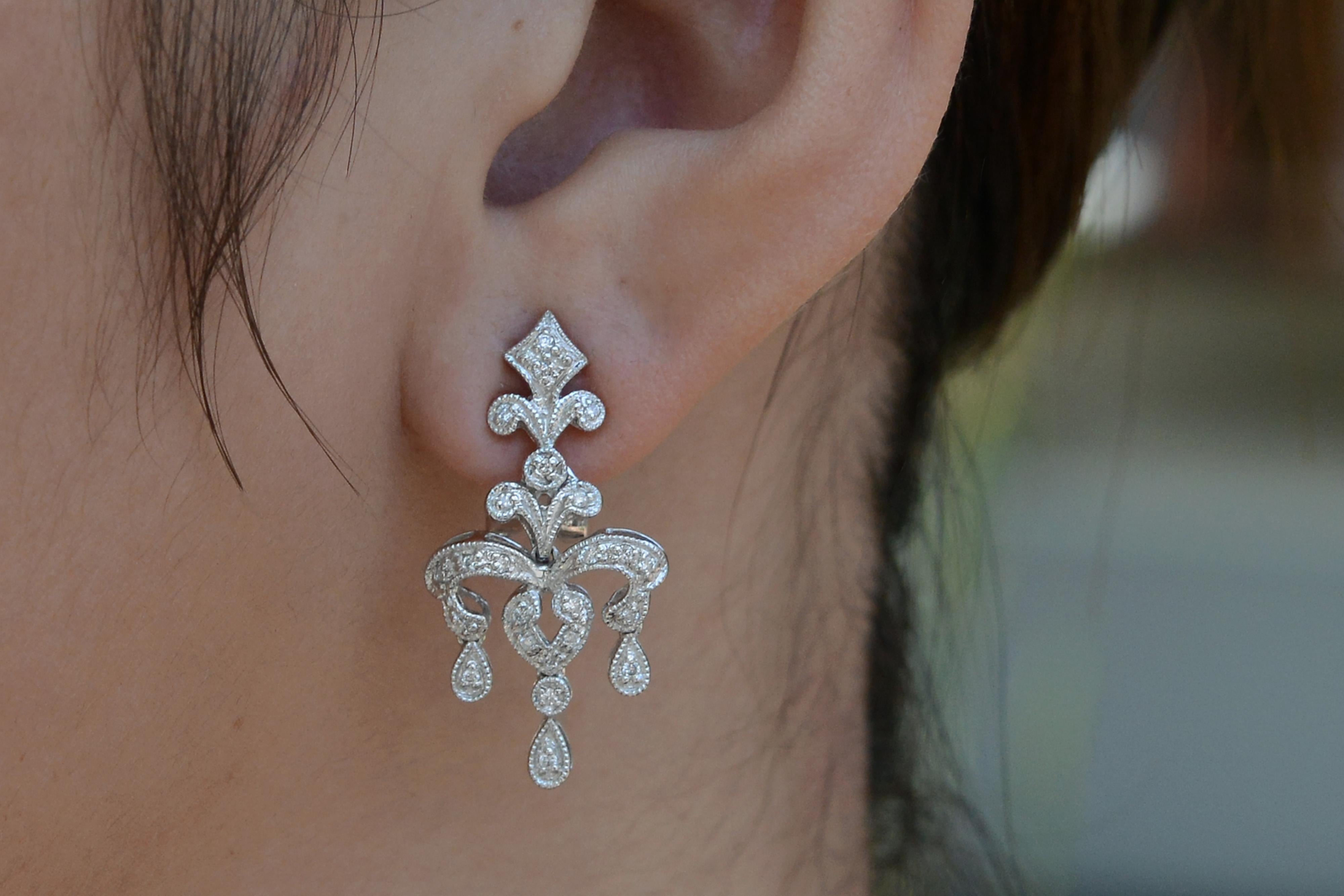 An affordable and luxurious estate find, these timeless dangle earrings are crafted with precision of 18k white gold. The milgrain adorned pavé setting of 48 round brilliant cut diamonds provides a shimmering light that sway with an elegant