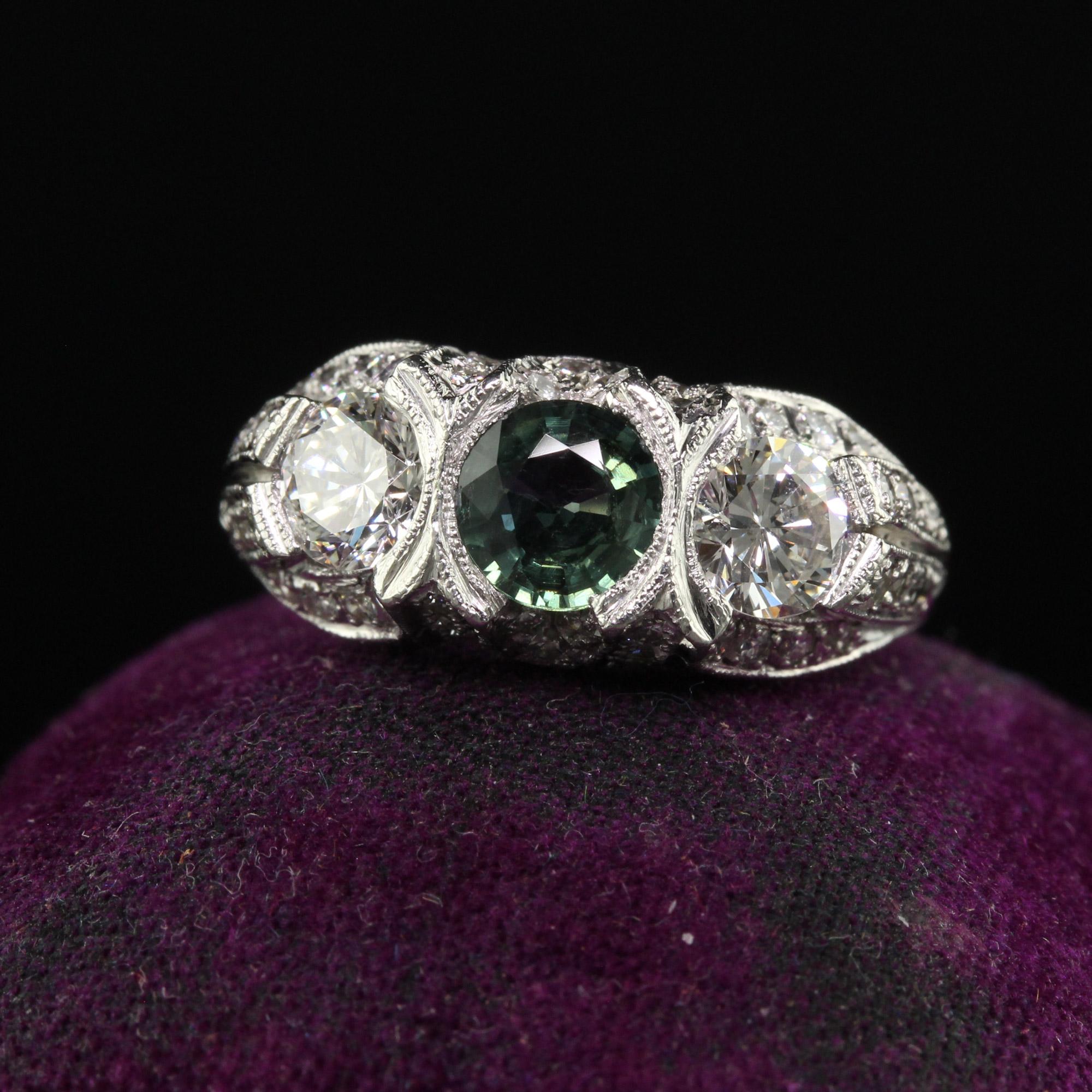 Beautiful Vintage Estate Retro Platinum Diamond and Green Sapphire Three Stone Ring. This beautiful retro three stone ring is crafted in platinum. The top of the ring has two transitional cut diamonds and a natural green sapphire center. The sides