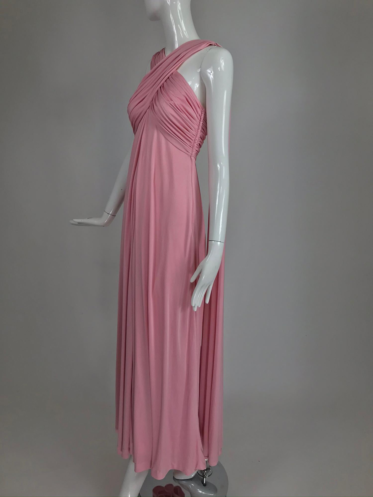 Vintage Estzevez pink matte jersey goddess gown from the 1970s. This amazing gown was undoubtedly inspired by Greek history. The fitted bodice is crossed and draped and the attached shoulder drapes fall to the hem in the back all very fluid and