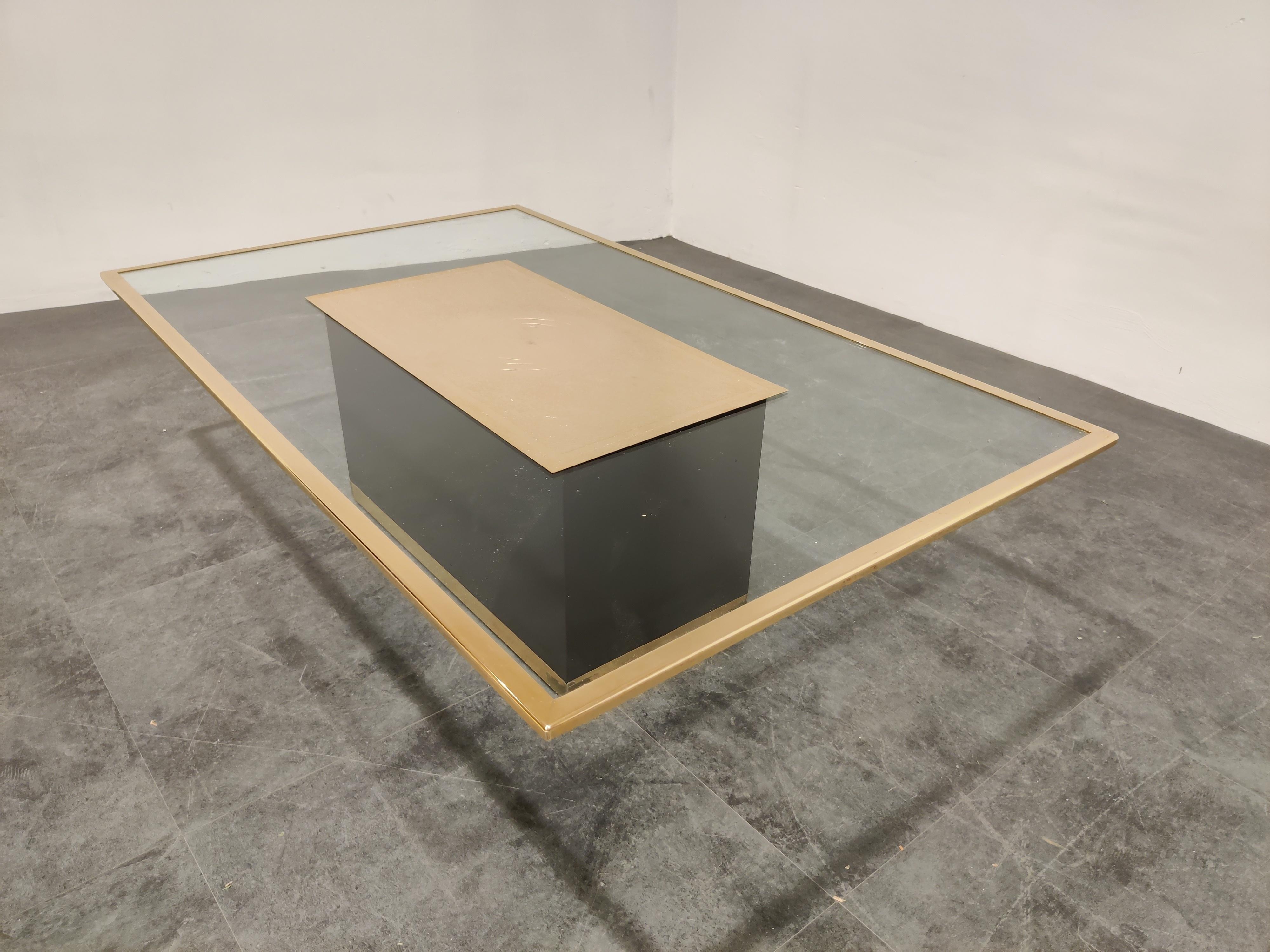 Rectangular coffee table featuring a clear glass top with a brass edge mounted on a black lacquered wooden base with a brass finish. 

The main feature of this coffee table is the etched brass plate signed by Ricco D '185'.

Little is known about