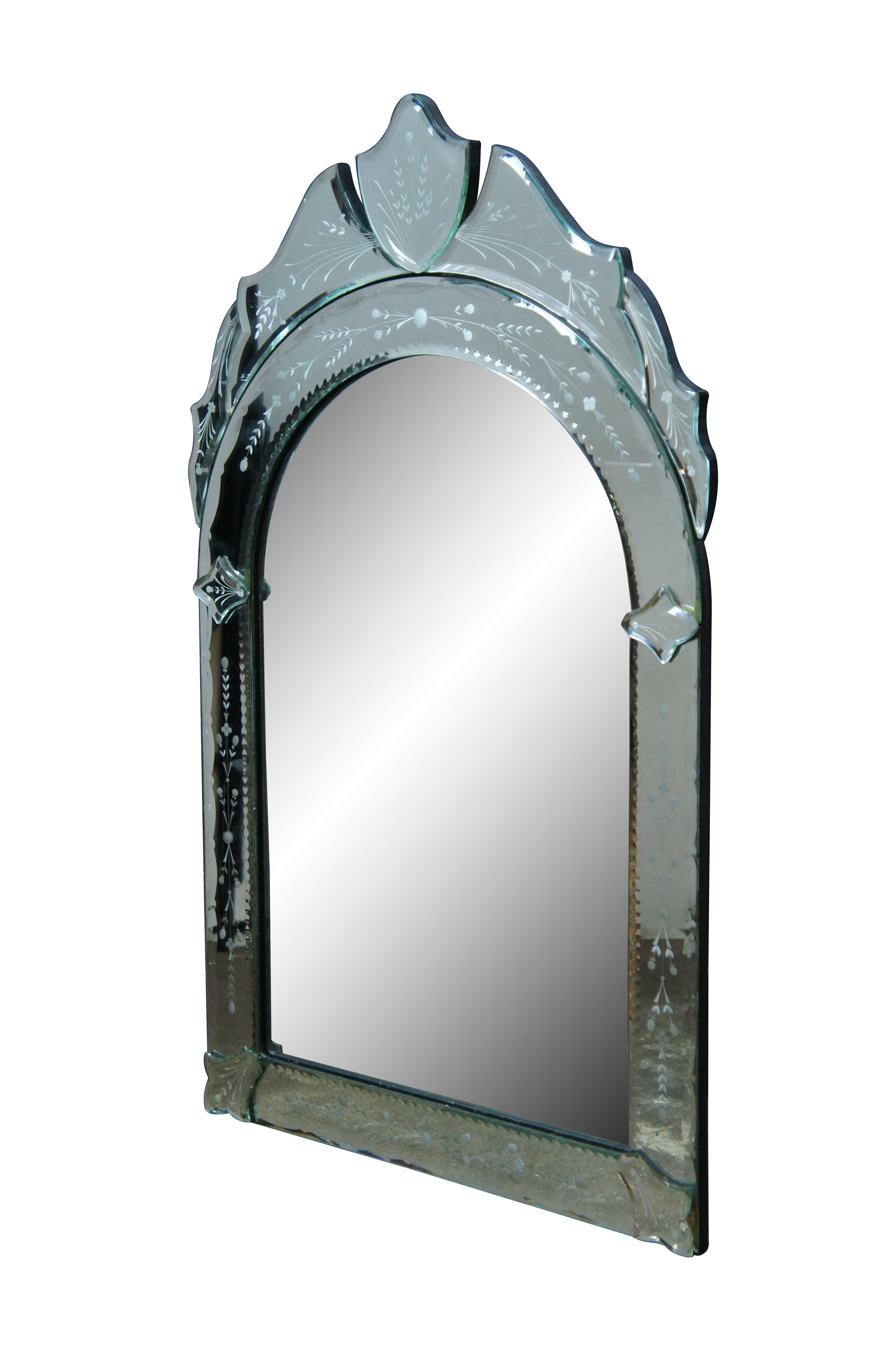 Late 20th century floral etched wall mirror. Arched Hollywood Regency design with molded panel crest and a reverse etched design of sprigs of leaves and flowers. Made in Philippines. 

Dimensions:
18.75