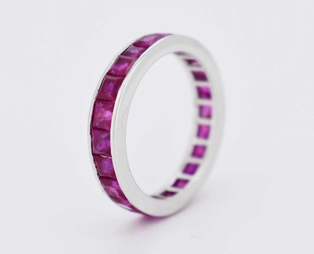 Vintage Eternity Band Ring from the 1990s. Made of 18k white gold (750/1000), it is set with 22 natural princess-cut rubies in an invisible setting all around the band, with a total weight of approximately 2.50 carats. In excellent