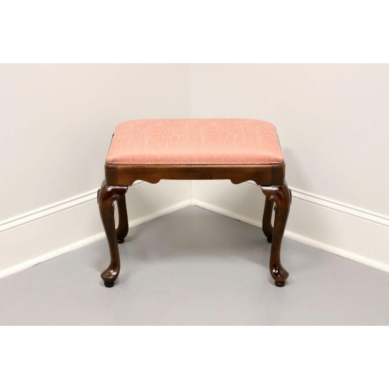 A Queen Anne style bench footstool by Ethan Allen, from their Traditional Classics Collection. Solid maple with dark finish and upholstered seat. Features salmon colored shimmery fabric, cabriole legs and pad feet. Made in the USA in the late 20th