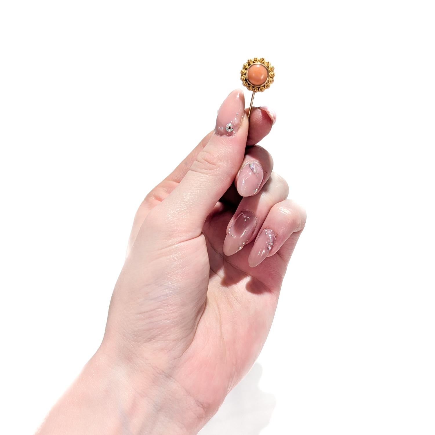 A fine vintage Etruscan Revival style stickpin.

In 14 karat yellow gold.

Bezel-set with a pink coral cabochon to the center surrounded by floriform gold wire work and granulation.

Simply a wonderful stickpin!

Date:
20th Century

Overall