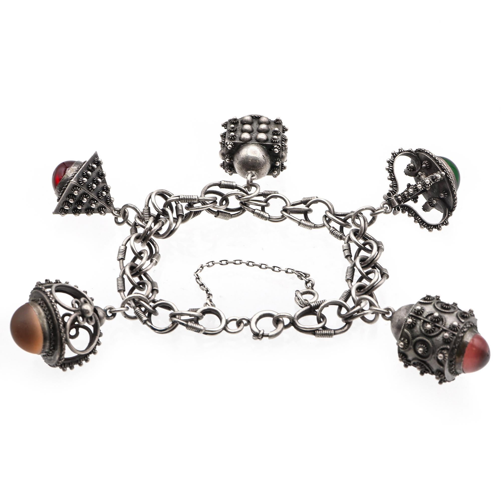 Crafted in sterling silver, it features a series of intricate links adorned with ornate charms, each set with a vibrant cabochon stone. A piece that embodies unique craftsmanship and artistic flair.

Weight: 50.1 grams
Stone: Paste
Charm Size: 16x22