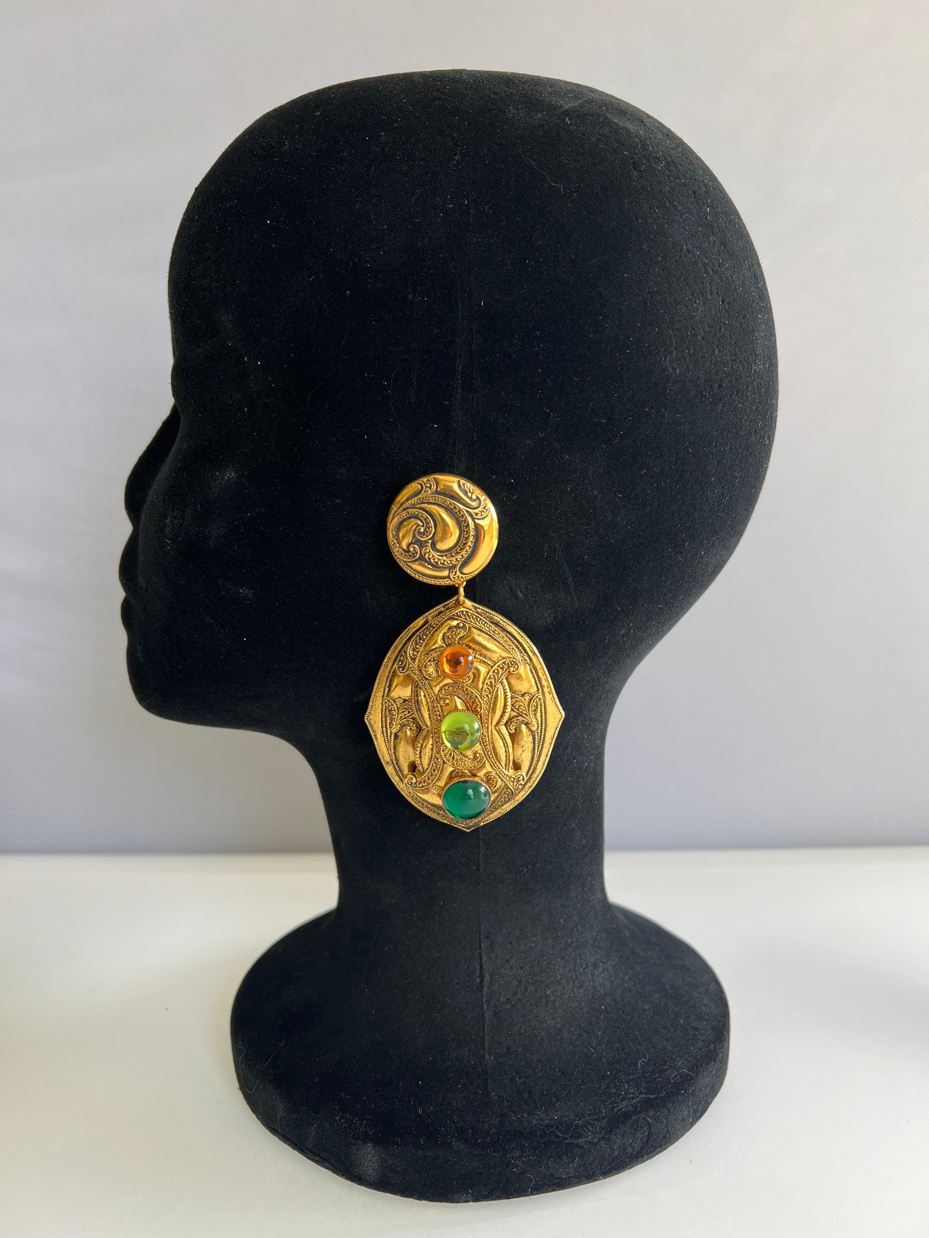Vintage French clip-on Etruscan style earrings. The gilt metal earrings have a very ornate motif and are adorned by three sizeable colored resin cabochons. 