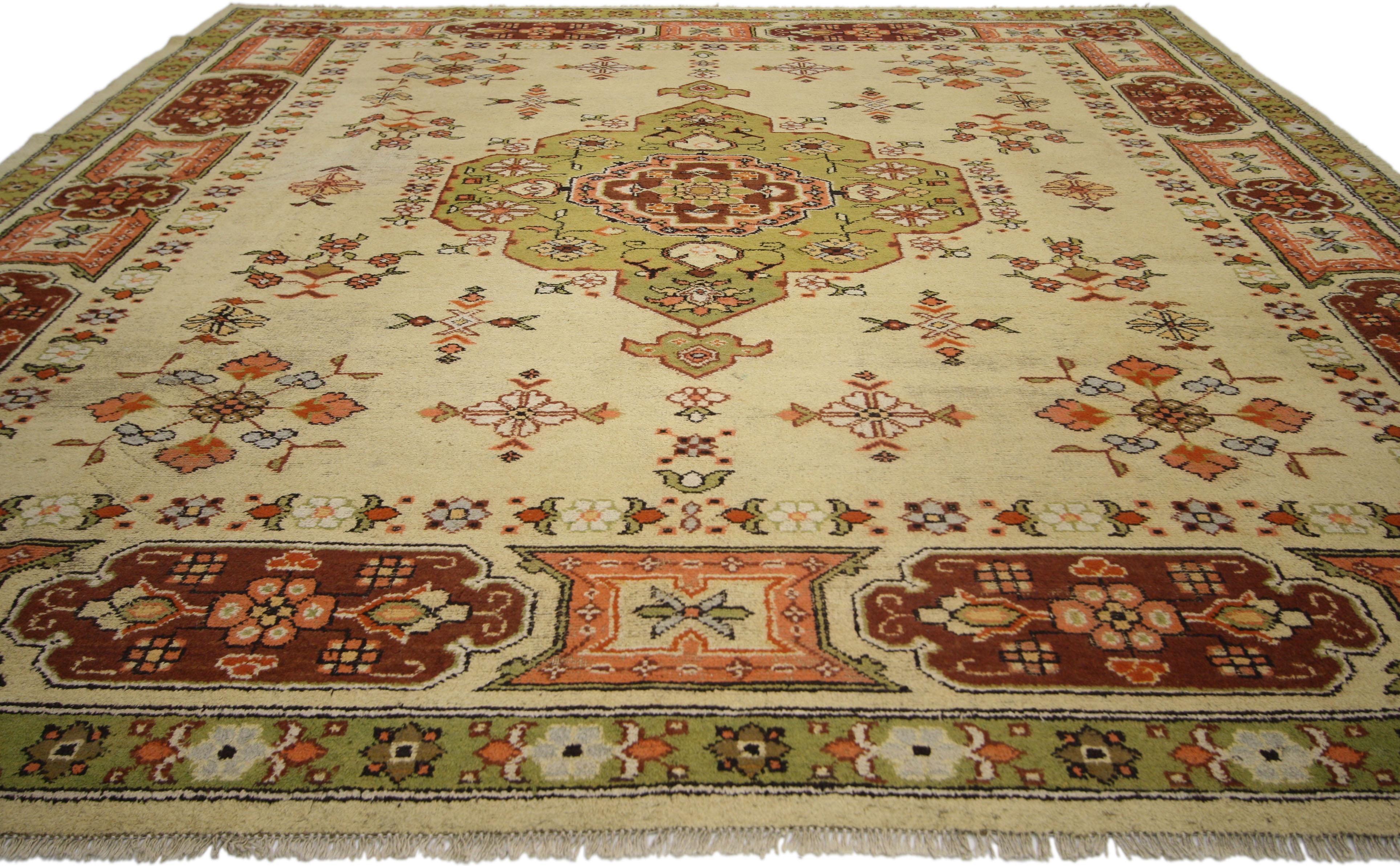 74687, this vintage European area rug with traditional style features an eight-point lobed centre medallion dotted with geometric motifs and stylized florals. It is framed with a cartouche border set with flowers in a unified, symmetrical