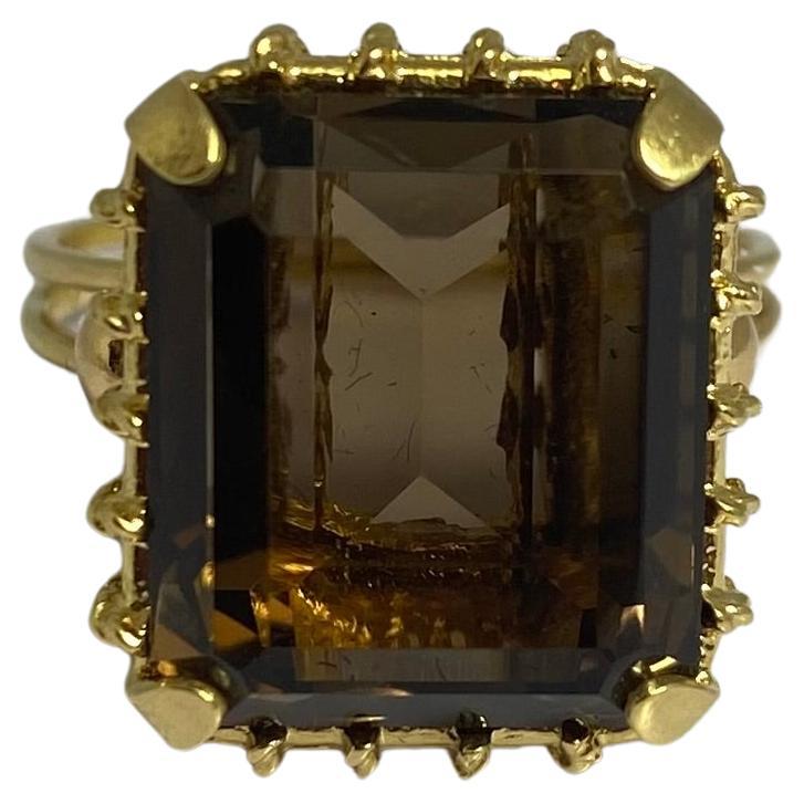 Gorgeous and timeless cocktail ring circa 1950s. Truly an unique yellow golden ring, captured by a smokey quarts. The decorative setting is made of 18 carat yellow gold with a baguette cut smokey quarts. This quarts has a beautiful deep color brown