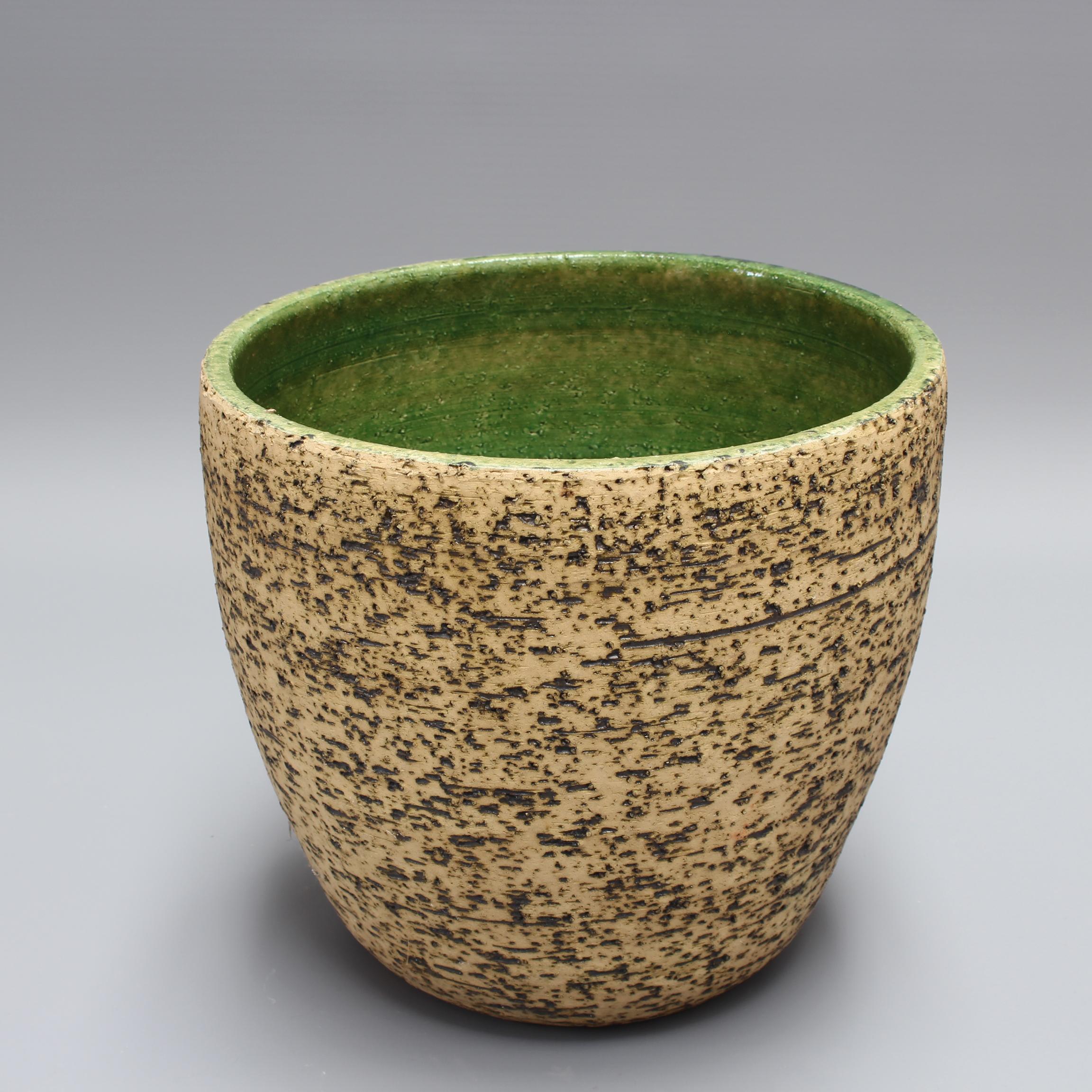 Vintage European earthenware cachepot (circa 1970s). A very rustic piece with a sandy matt hue accented by incised darker markings encircling the body up to the lip. The lip and the interior are green and smoother to the touch contrasting with the