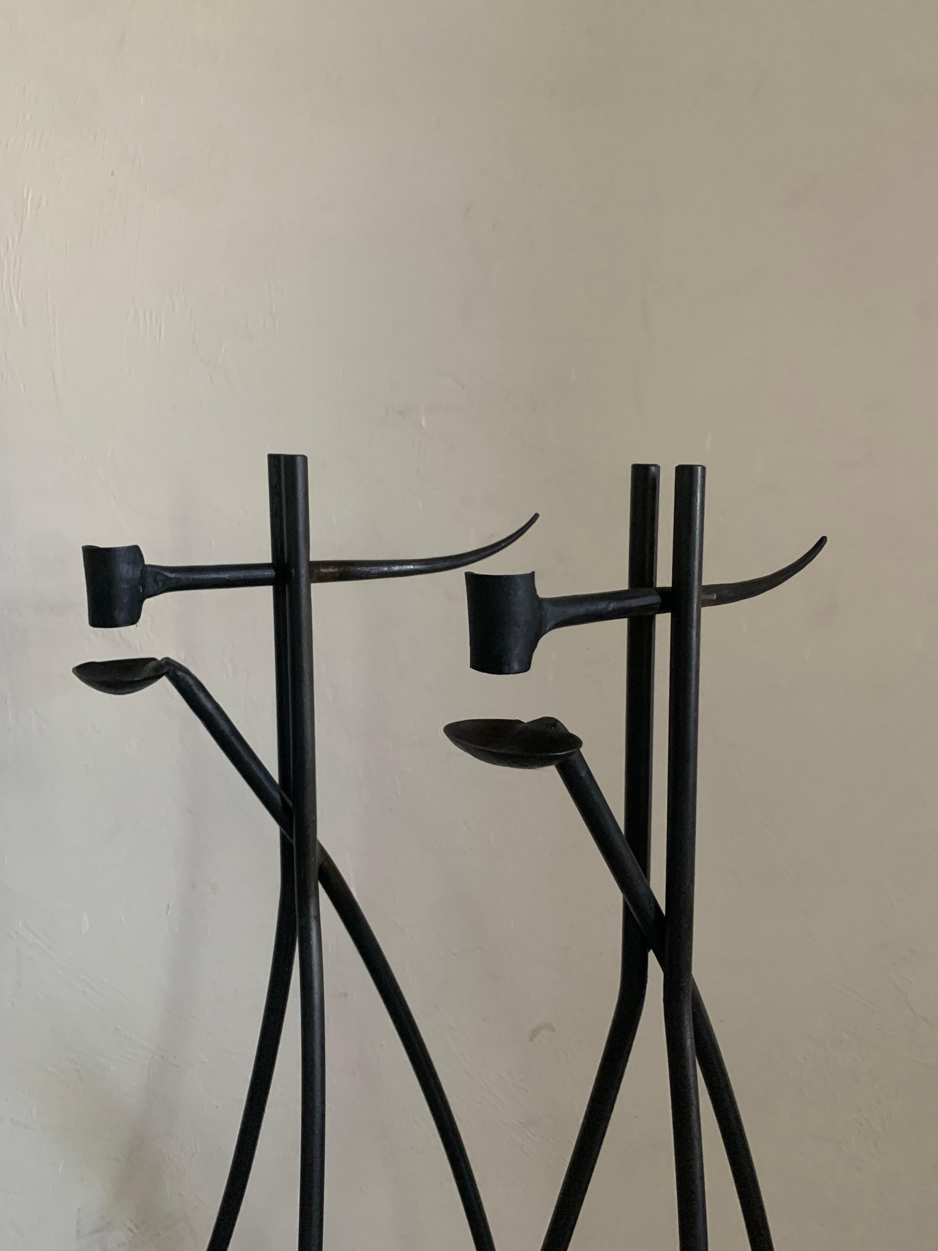 Beautiful pair of hand Forged iron candlesticks. European in nature, likely French. Uncertain of age but appearance suggests early 20th century. 

Exceptional blend of modernism with traditional craftsmanship. 