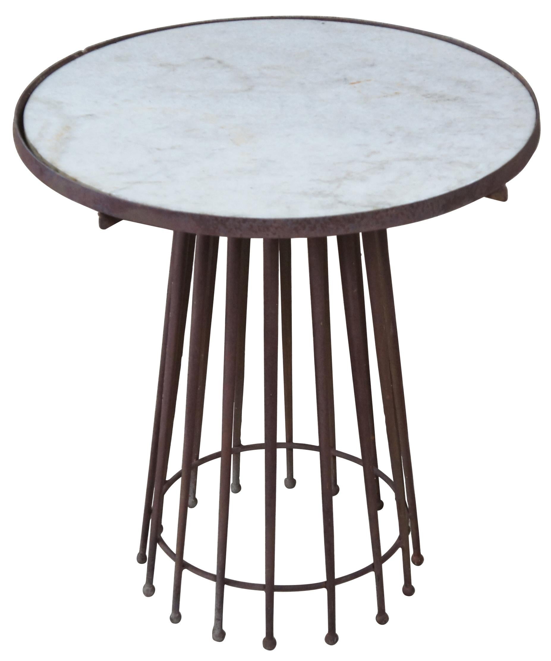 European marble-top and wrought iron side accent table. Features a circular white marble top that rests within a wrought iron band and sits above sixteen wrought iron needle form legs also in a circular formation with stretcher. Measure: 26
