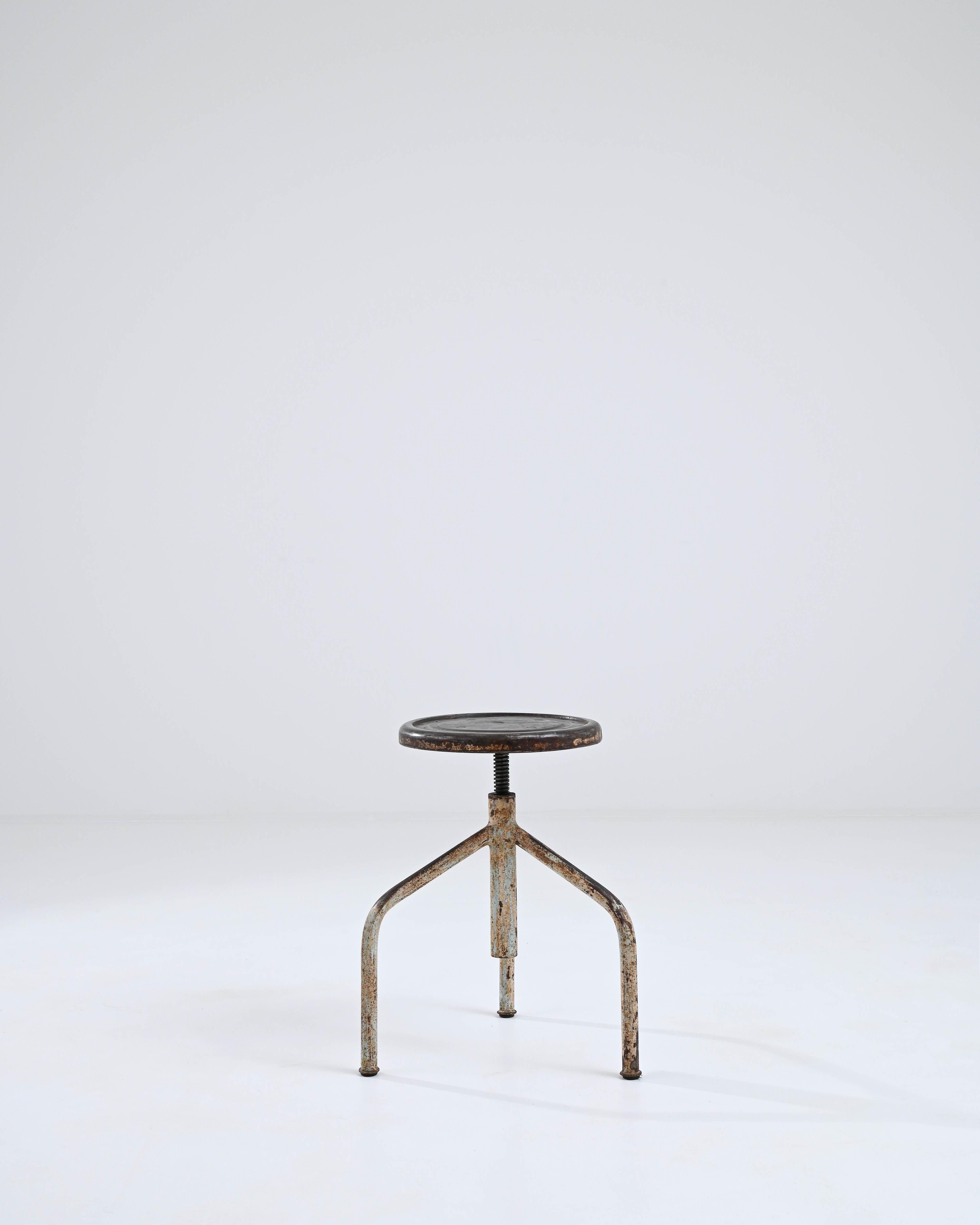 A metal stool made in 20th century central Europe. The pleasingly simple tripod structure that composes this industrial stool has been coated in a fascinating patina, with browns, beiges, and greens mingling together in surprising harmony.
