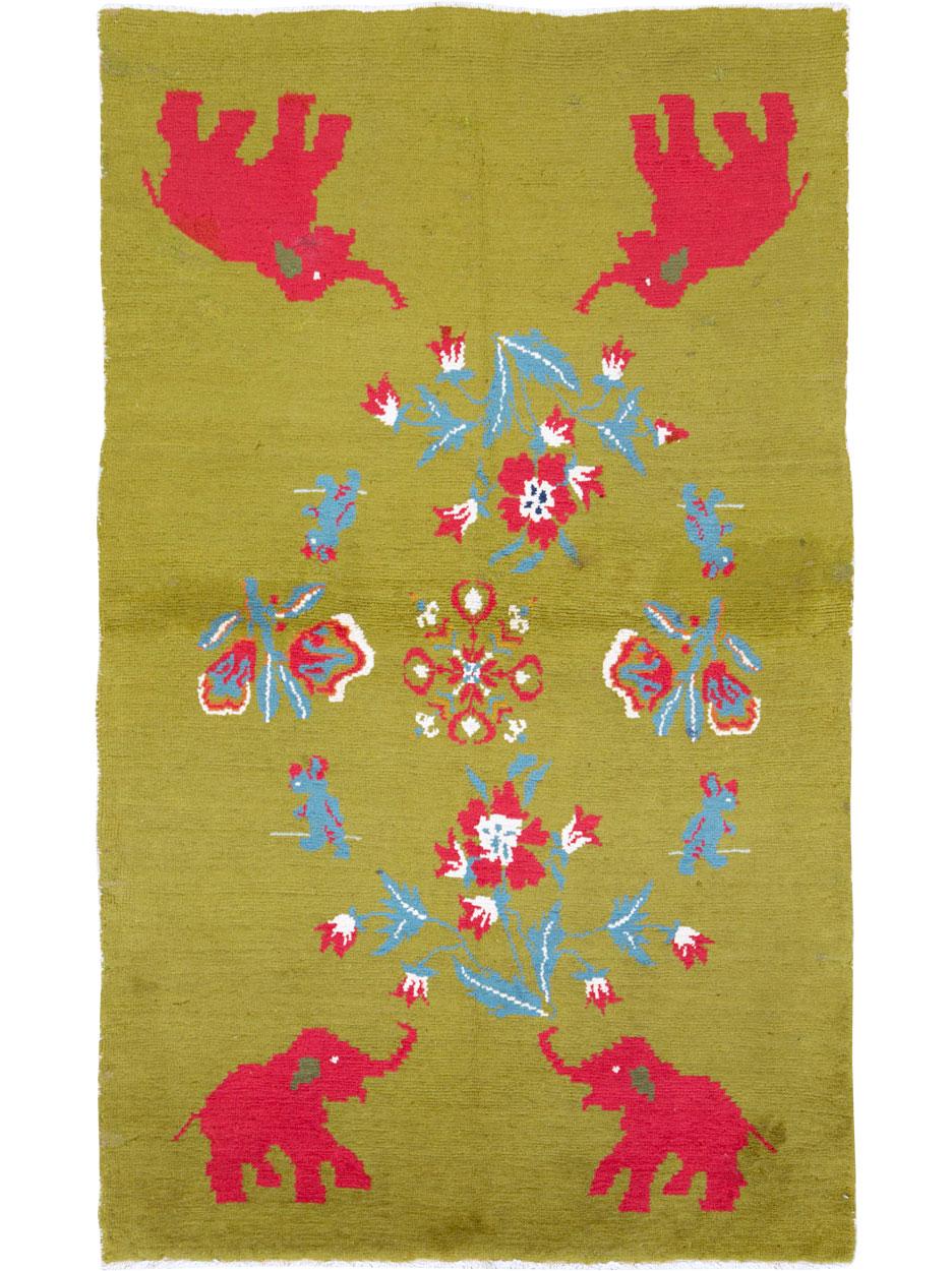 A vintage Swedish Pictorial rug handmade during the mid-20th century with saturated red elephants on the corners of the green field. An allover floral medallion with four teddy bears is composed in shades of light blue, white, and the same red as