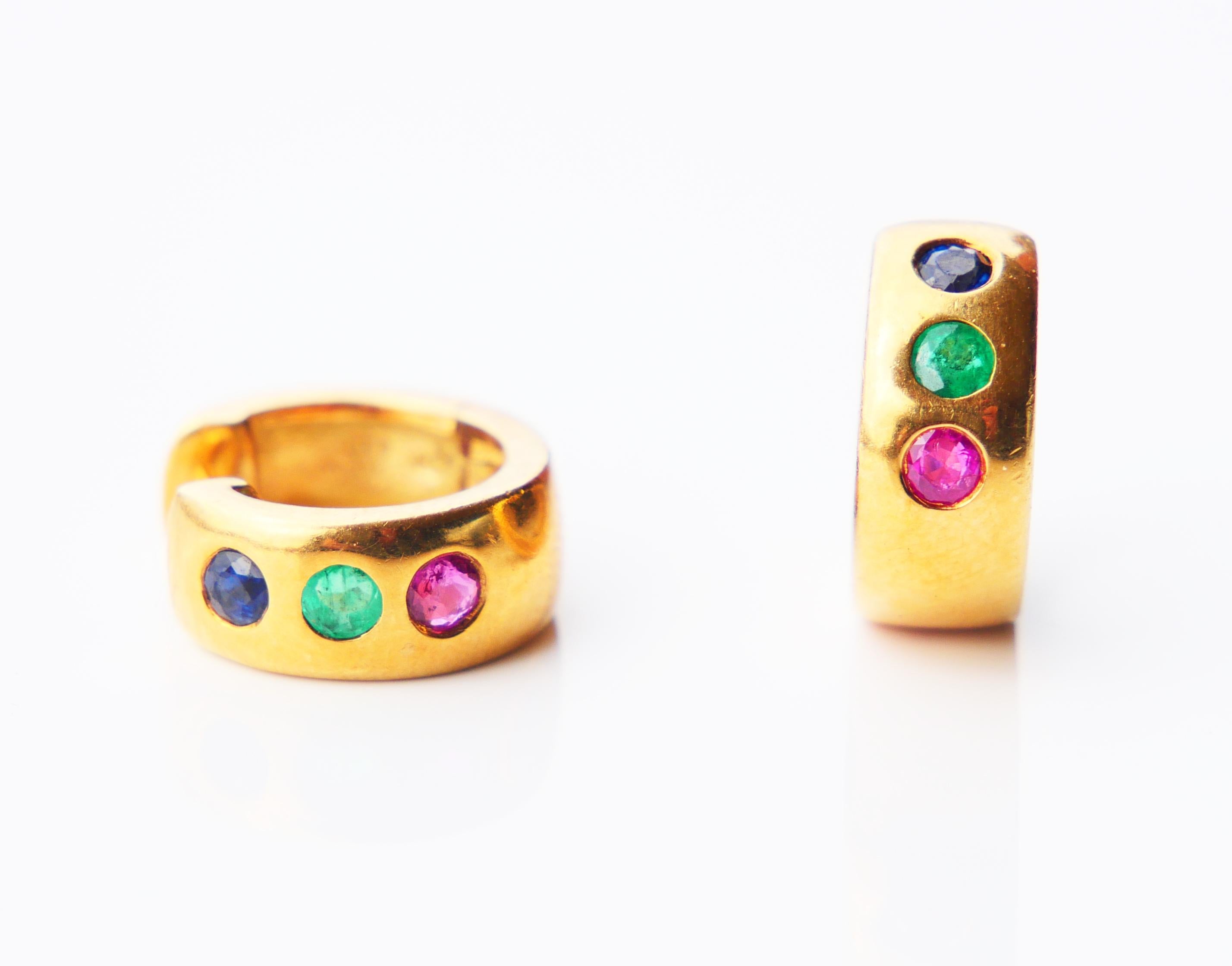 A pair of fine Three Stones studs from ca. 1960s -1970s in solid 18K Yellow featuring old diamond cut natural Blue Sapphires, Green Emeralds, and Red Rubies Ø x 2.5 mm each / ca. 0.1 ct each.

Each earring Ø 13 mm x 5 mm wide.

Both hallmarked 750