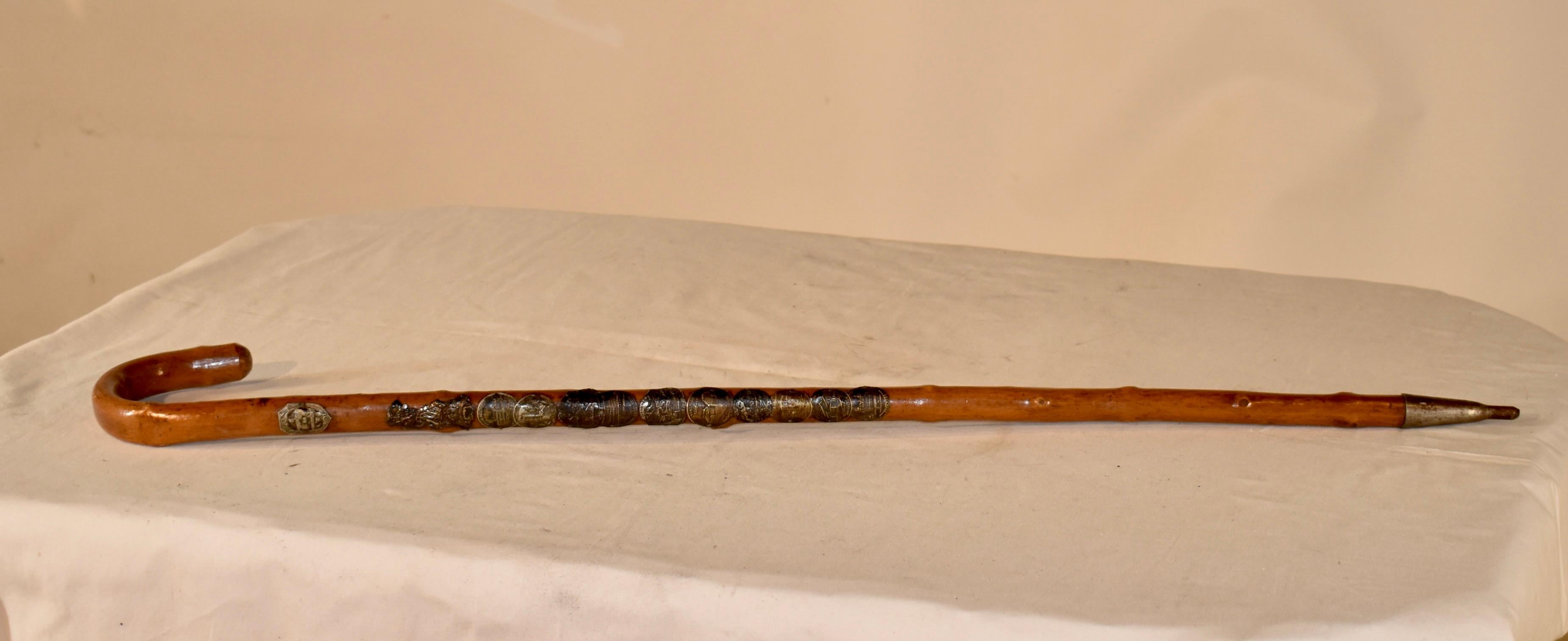 Early 20th century hickory thorn walking stick from Europe.  This walking stick has 12 badges, which were acquired by the hiker going from village to village and earning those souvenir badges.  These were all the rave in Europe to show all of the