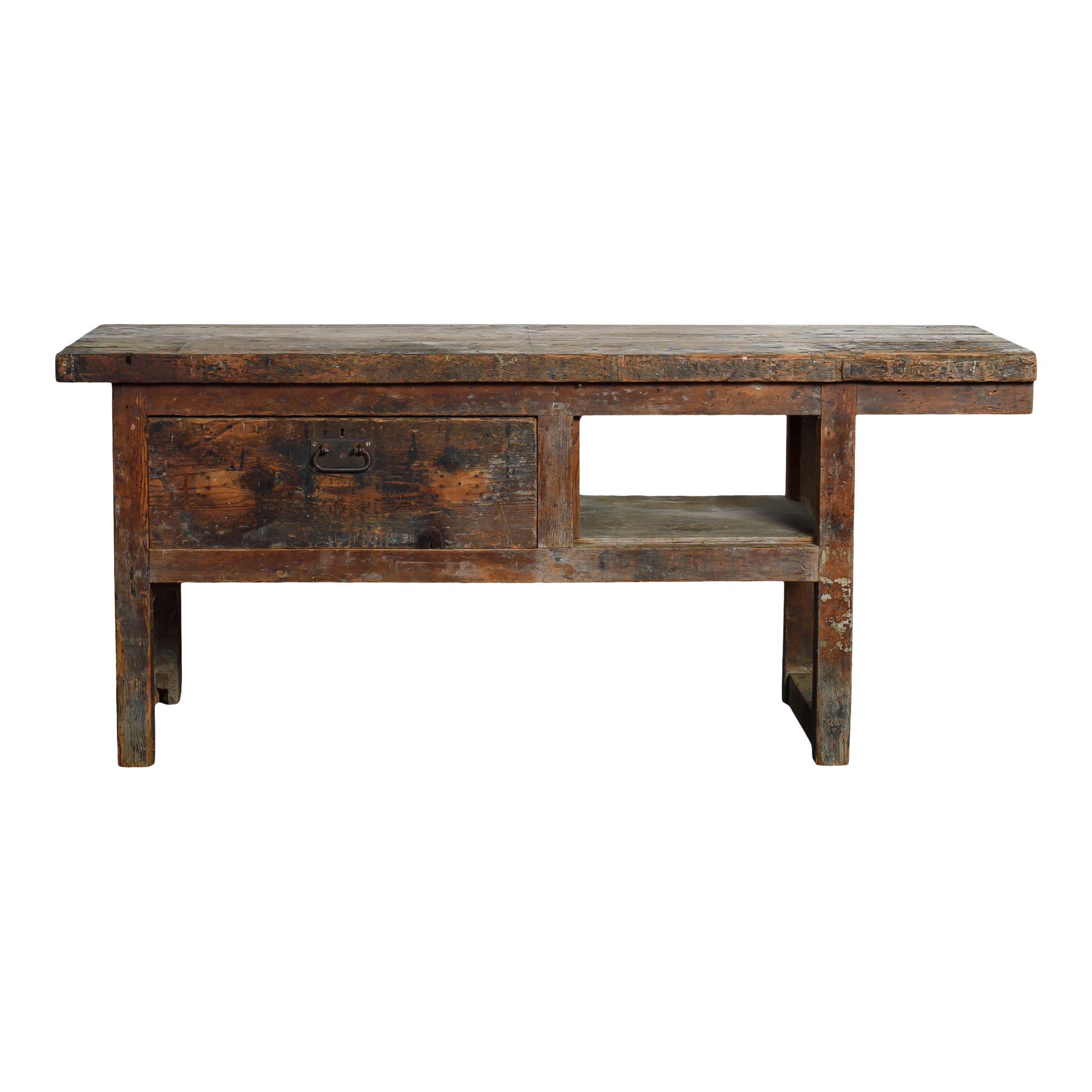 Banco de trabajo vintage de madera con cajón procedente de Europa. La pieza se hizo para que fuera funcional, por eso tiene un cajón sencillo pero grande a la izquierda y un recorte y repisa en el lado derecho. Esto la convierte en una pieza única y