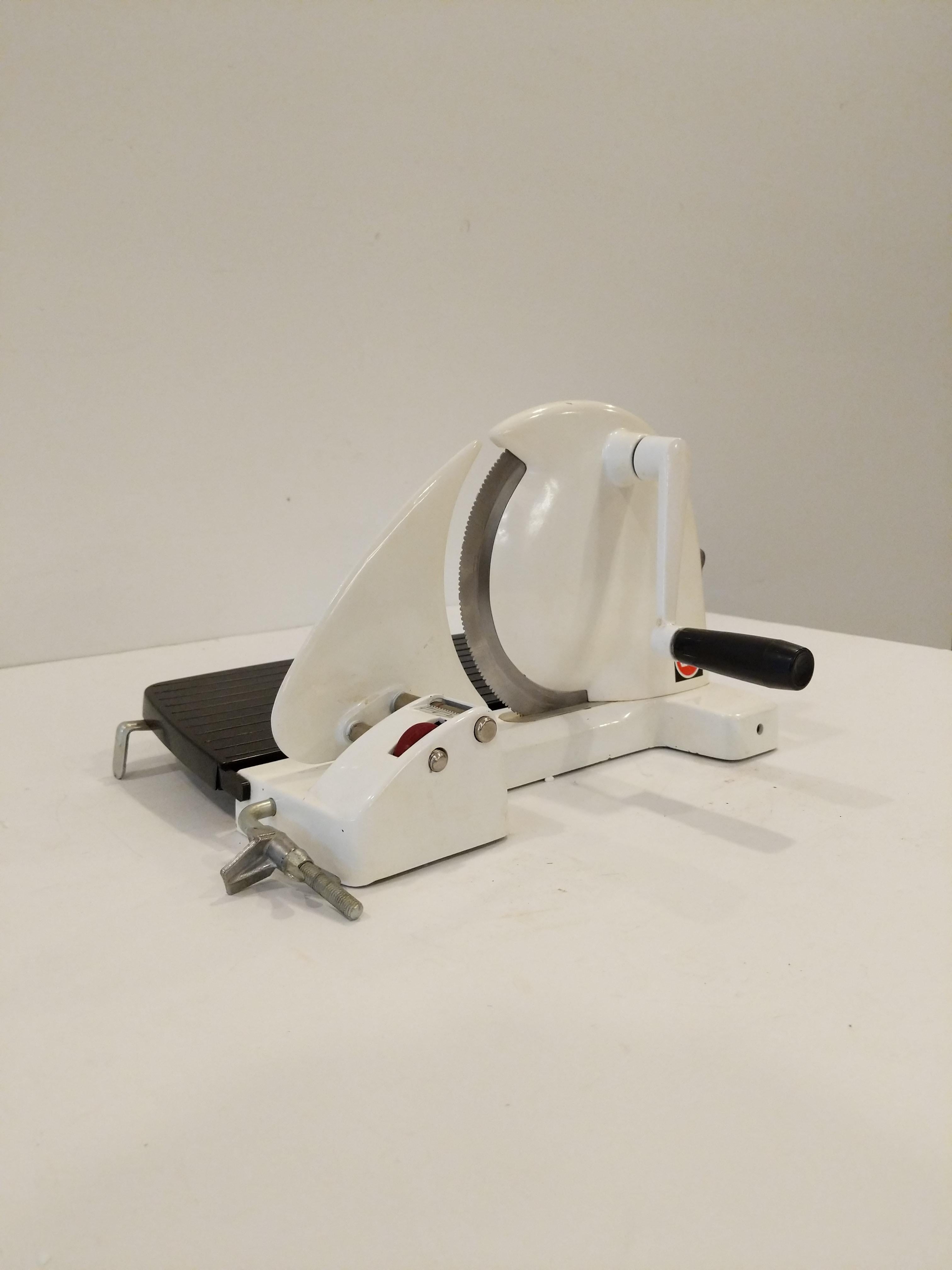 Authentic vintage Danish Eva bread / cheese / meat slicer in white.

This slicer is in good condition overall and expectedly shows its age a bit.

Clamp bar secures slicer to counter top.

Slicer folds down flat for easy storage.

Ref: RV27-045