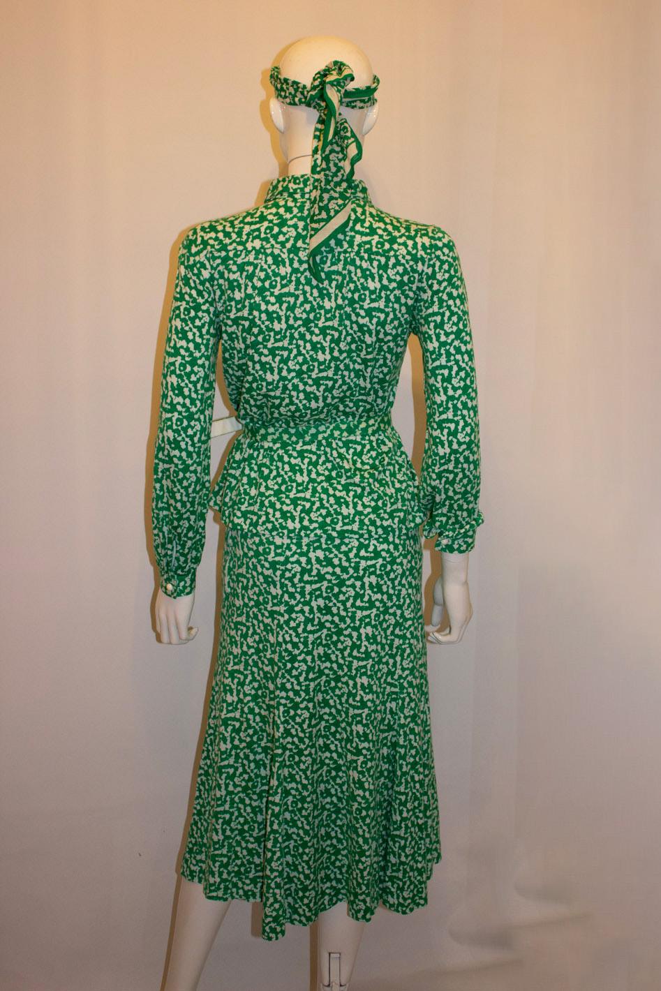 A fun vintage outfit by Robert Janan. In a green and white print , the outfit comprises a shirt /jacket top with a four button opening and button cuffs. The top has gathering at the back of the yoke, and the skirt is fully lined. In addition there