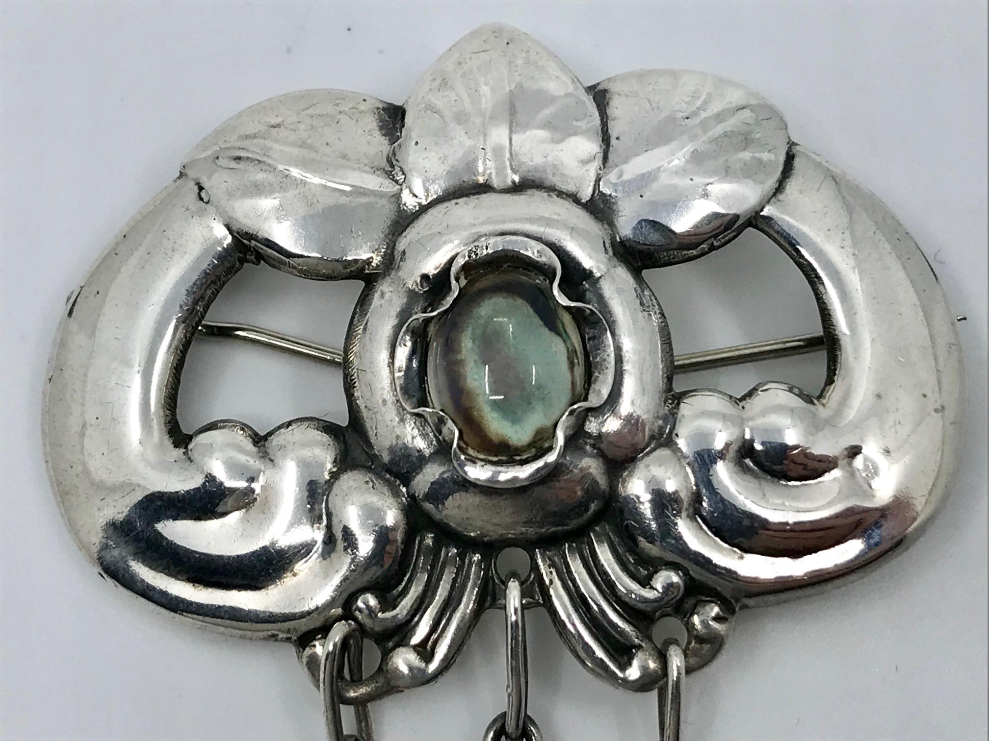 Vintage silver Evald Nielsen brooch mounted with a single moonstone and with three moonstone drops.
Measures 4″ x 2 1/8″ (10cm x 5.4cm).
Hallmarked, “Evald Nielsen 830s”. Evald Nielsen was a Copenhagen silversmith, active from 1905 until his death