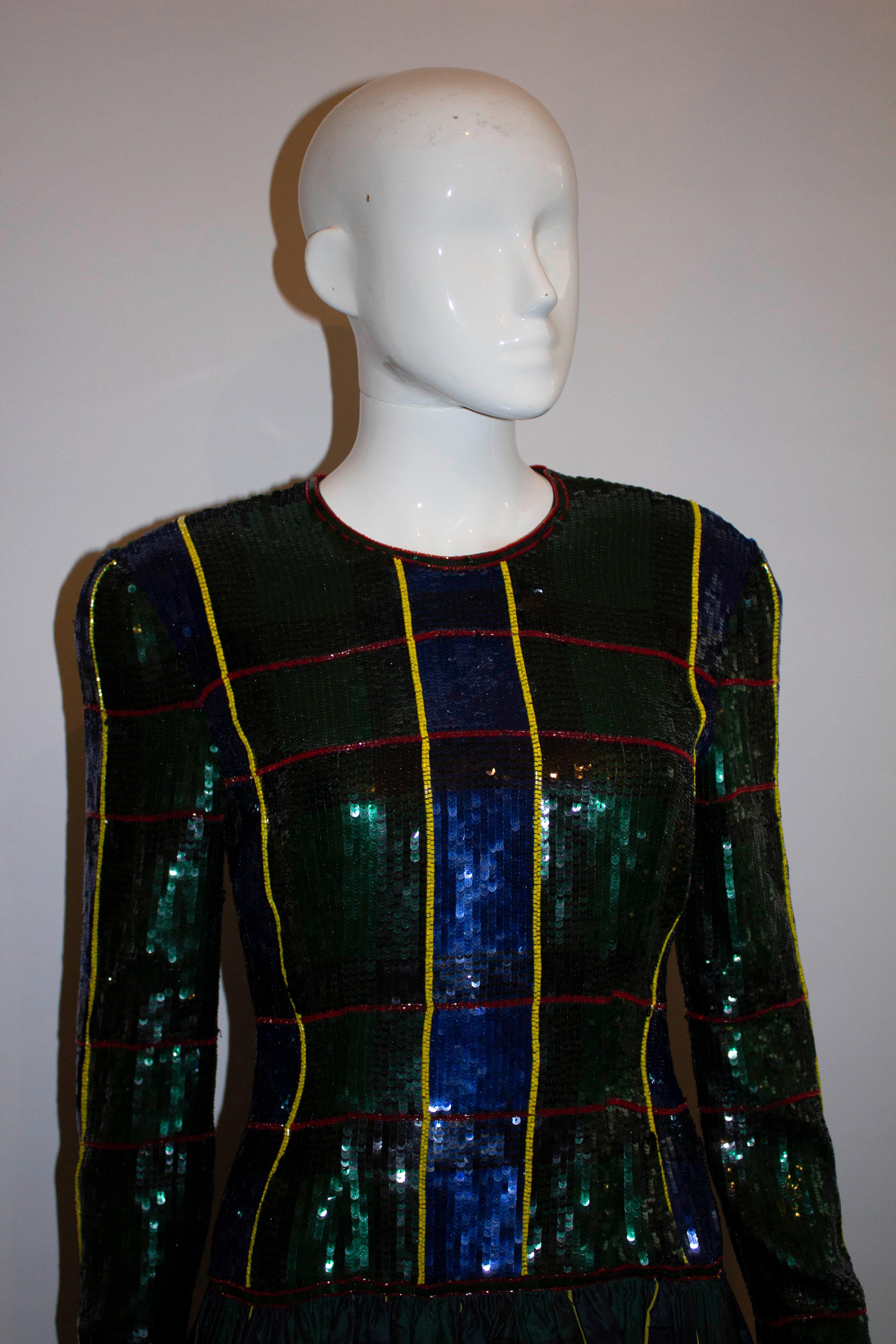 A stunning vintage evening gown by Escada Couture. The dress has a sequin top in a tartan design, with long sleaves with zip openings at the wrist.  The skirt is full with net underneath.

Measurements: Bust 36'', length 42'' plus 1 1/2'' hem. 