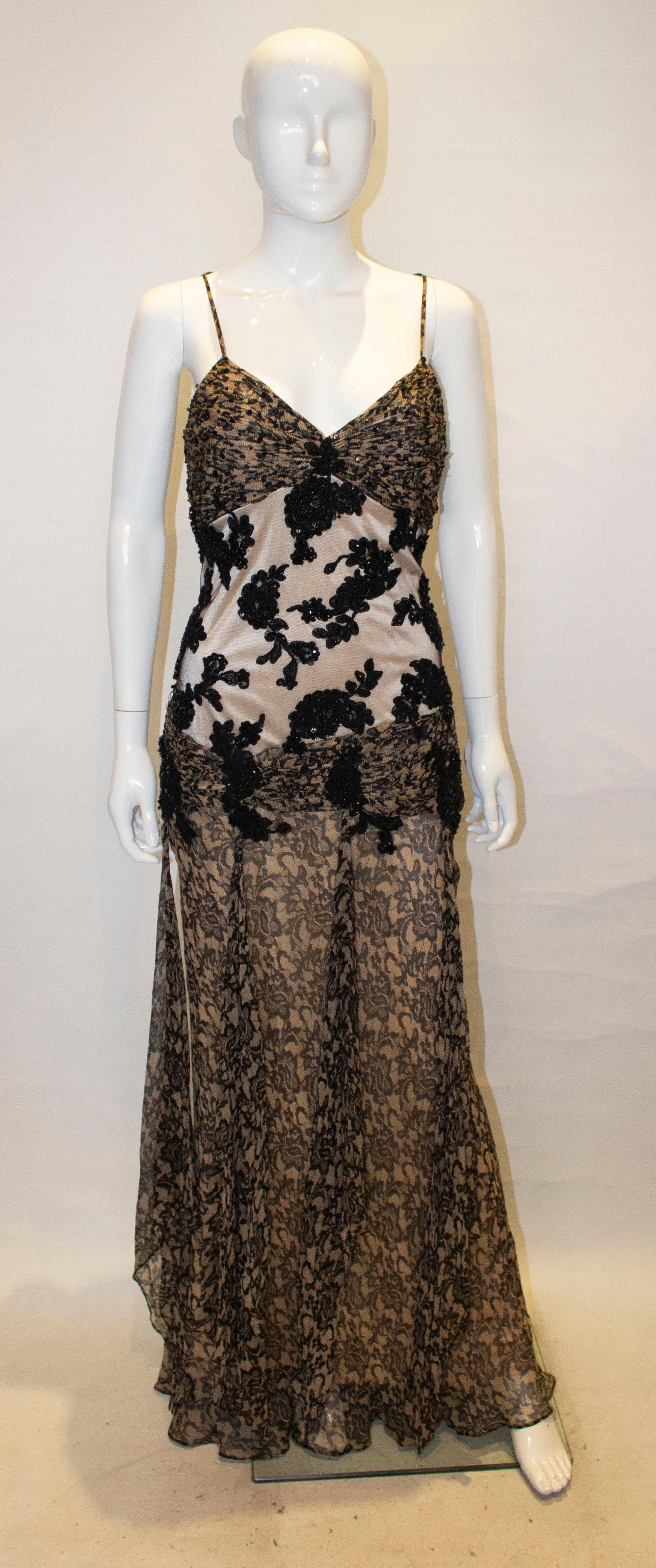 A fun gown by Sue Wong Noctrune. The dress has net and bead detail at the back with a side zip opening and spagetti straps. It has sequin detail over the bust area,  decorative loose fabric at hip leval and is fullly lined.