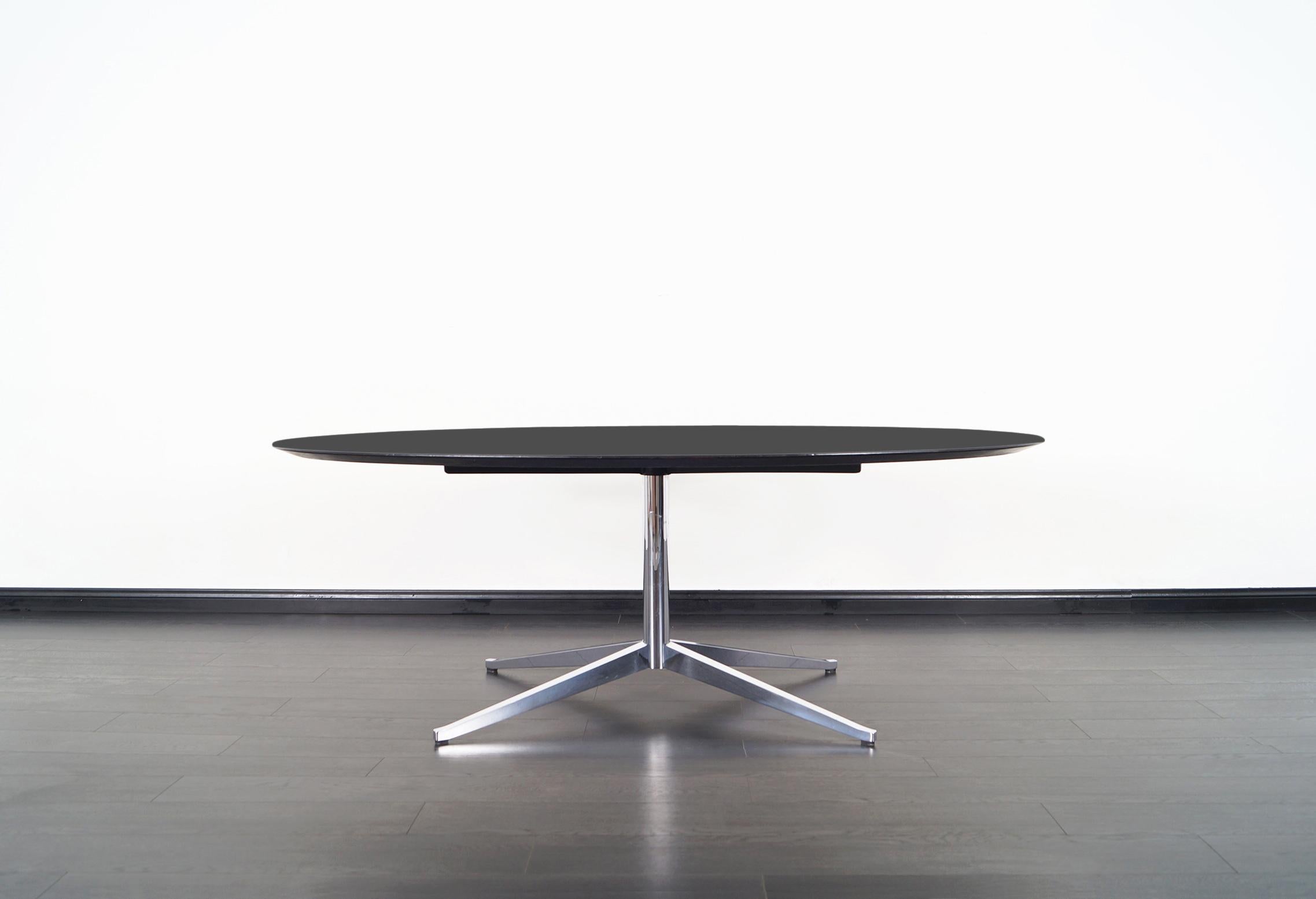 This amazing vintage table was designed by Florence Knoll for Knoll International in the United States, circa 1960s. Its versatile allows it to serve as a desk, dining table, or conference table. This iconic design features an ebonized top that sits