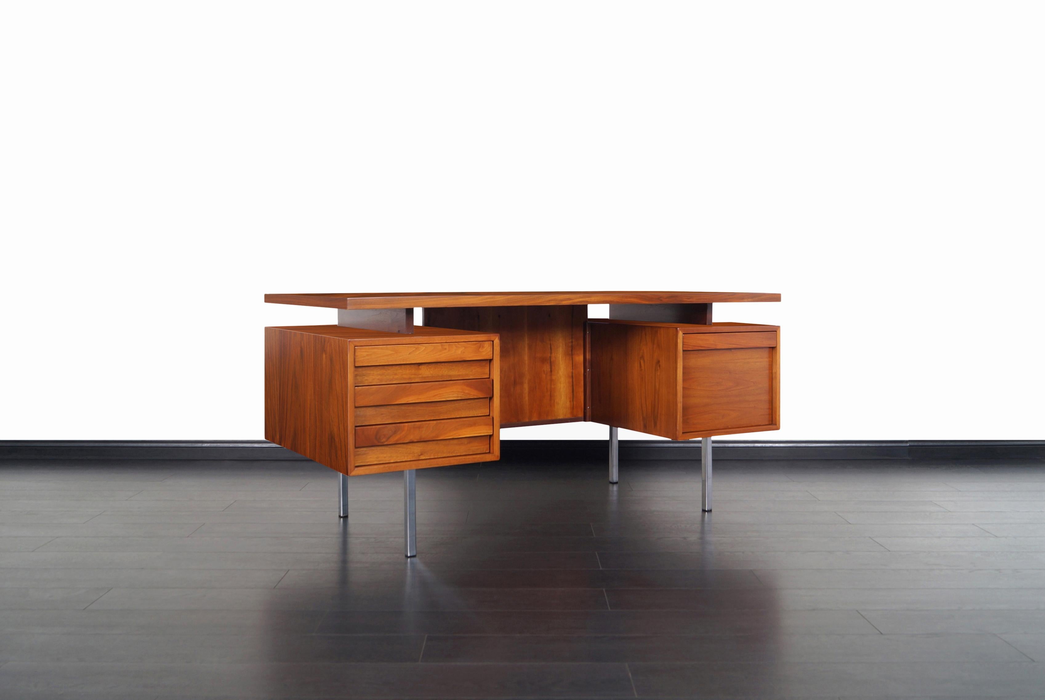 Vintage executive desk designed by John Keal for Brown Saltman in the United States. This exceptional crafted desk features three pull-out drawers and a file drawer all with sculpted pulls. On the opposite side of the desk there's an open space for