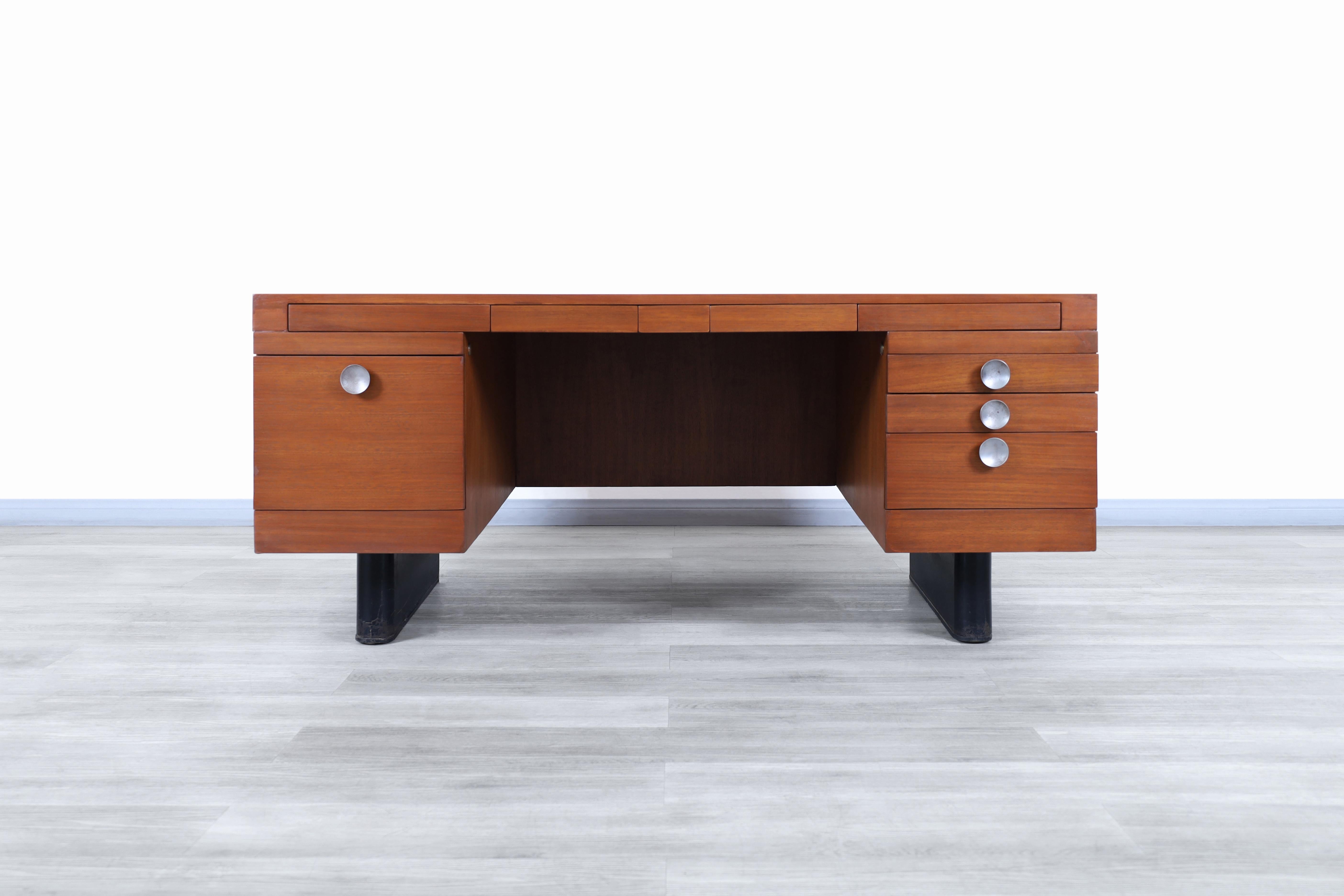 Exceptional vintage executive walnut desk designed by Gilbert Rohde for Herman Miller in the United States, circa 1940s. This desk represents in a significant way the expression of the art deco movement through its elaborate construction lines and