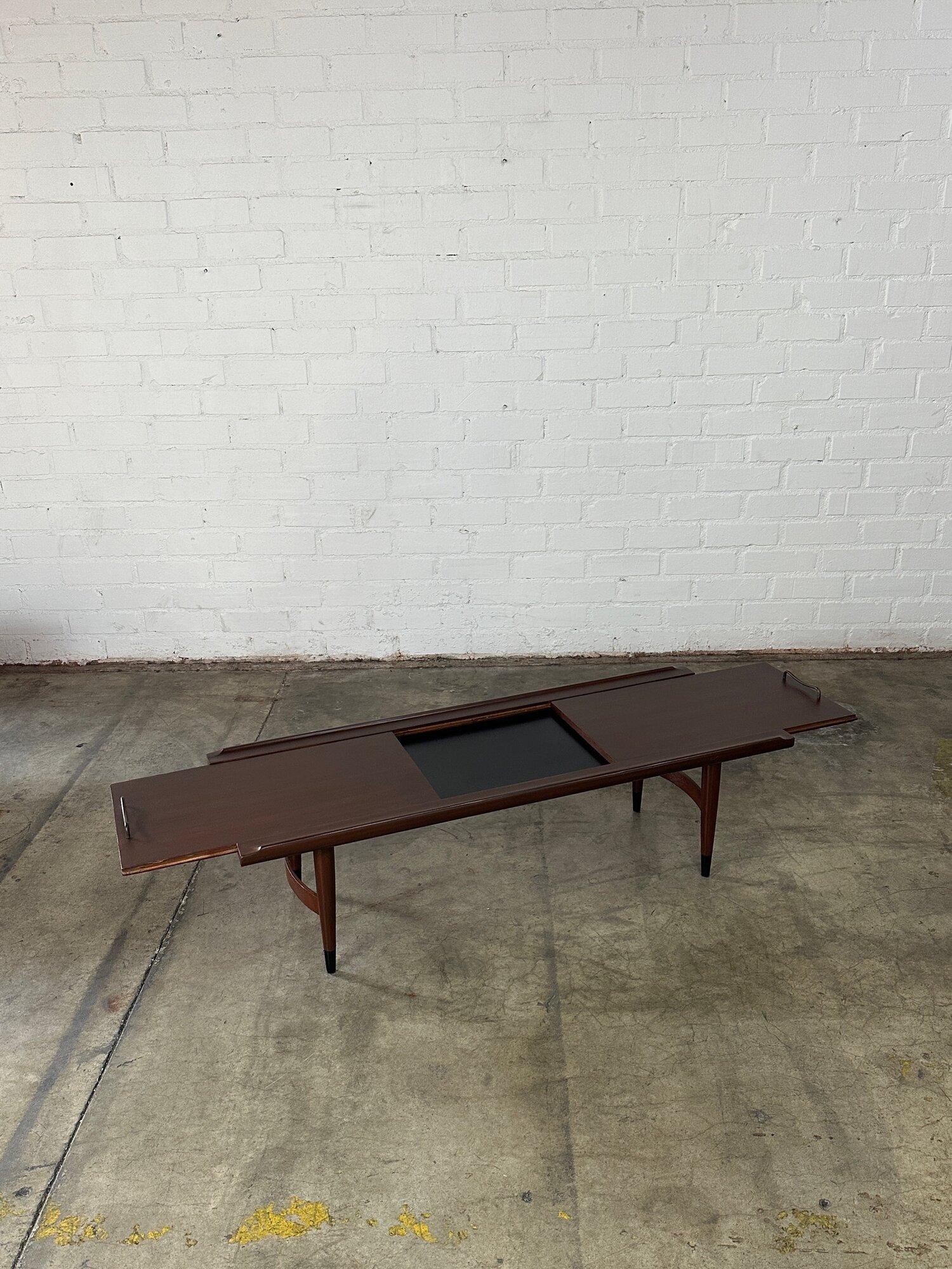 W52 D19 H16 Open W69.5

Fully restored coffee table finished in a dark walnut. Item is structurally sound and opens to reveal a durable laminate center. Item has nice raised edges and curved leg stretchers. Coffee table has original hardware and