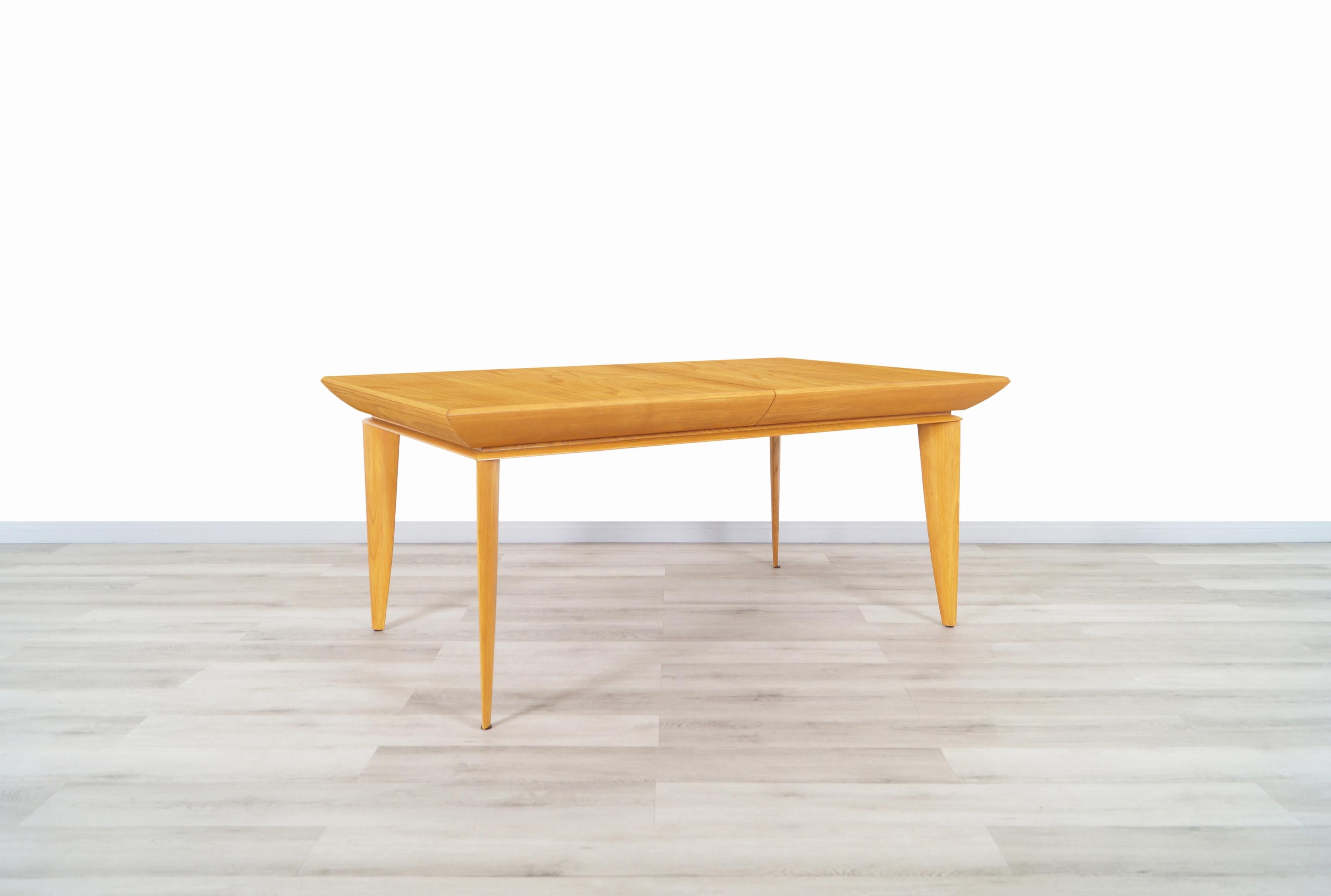 Table à manger vintage en chêne en expansion conçue par l'architecte et designer de meubles Paul Laszlo pour Brown Saltman aux États-Unis. Cette table de salle à manger spectaculaire présente un corps en bois de chêne avec des pieds en forme de