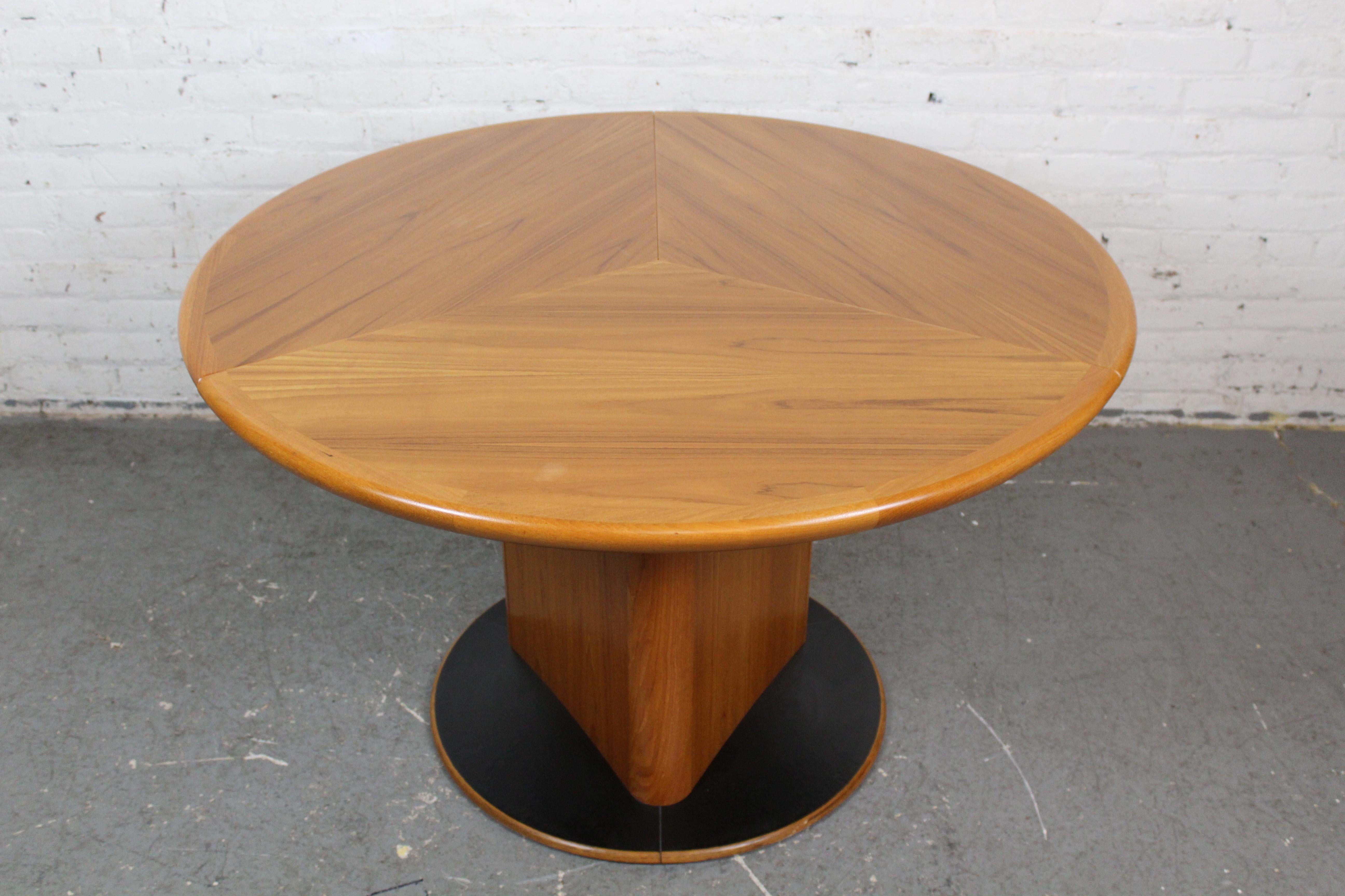 Découvrez la véritable magie de l'ingénierie du mobilier danois avec cette table en teck transformable, fascinante à l'infini. Avec une base robuste supportant un plateau de table rond en teck de 47