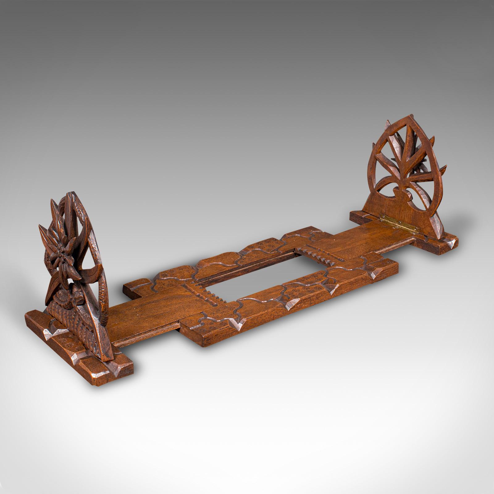 Questo è un vetrino allungabile vintage. Un porta-romanzi decorativo anglo-indiano in teak, risalente all'inizio del XX secolo, circa 1930.

L'audace decorazione intagliata accentua questo generoso scivolo per libri.
Mostra una patina invecchiata e