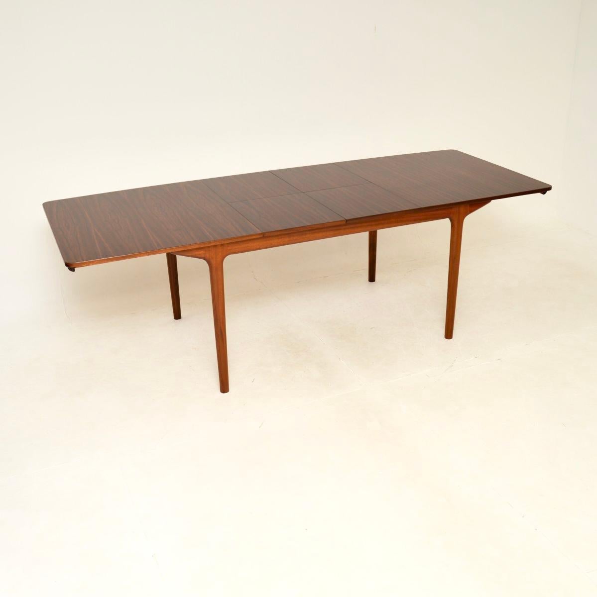 A stylish and extremely well made vintage extending dining table by McIntosh. This was made in Scotland, it was designed by Tom Robertson and dates from the 1960’s.

It is of superb quality, the top has stunning grain patterns and sits on a solid