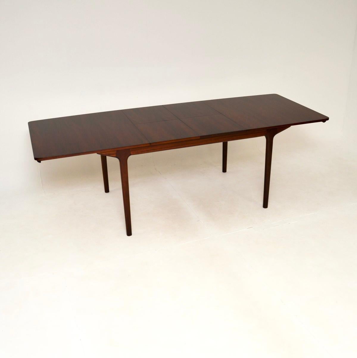 A stylish and extremely well made vintage extending dining table by McIntosh. This was made in Scotland, it was designed by Tom Robertson and dates from the 1960’s.

It is of superb quality, the top has stunning grain patterns and sits on a solid