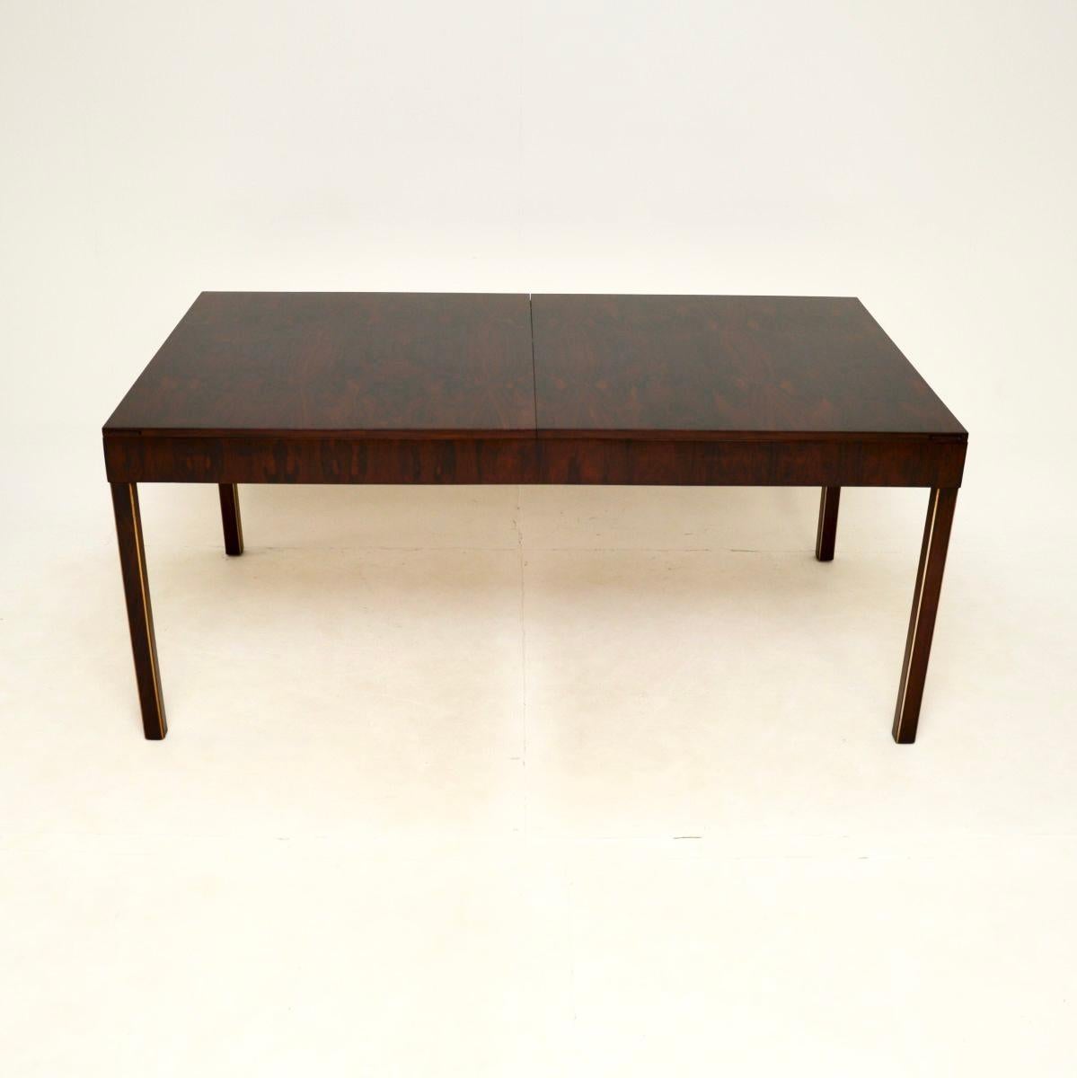 Un tavolo da pranzo allungabile vintage elegante ed estremamente ben fatto. Questo modello è stato prodotto in Inghilterra e risale agli anni '1960.

È di qualità superba, il piano ha delle venature meravigliose e poggia su una base con finiture in